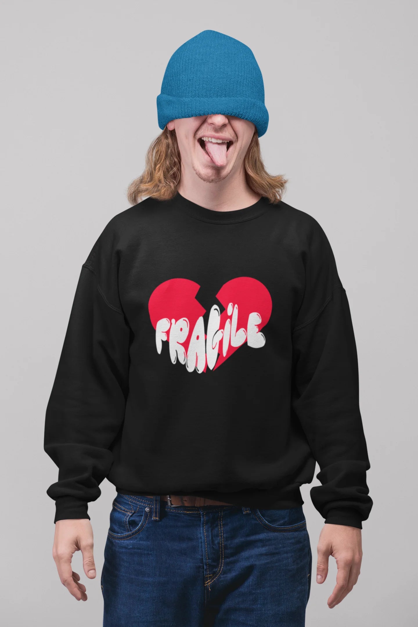 2nd front view of a male model wearing a black sweatshirt with a broken heart design and the word "Fragile" in melting text.