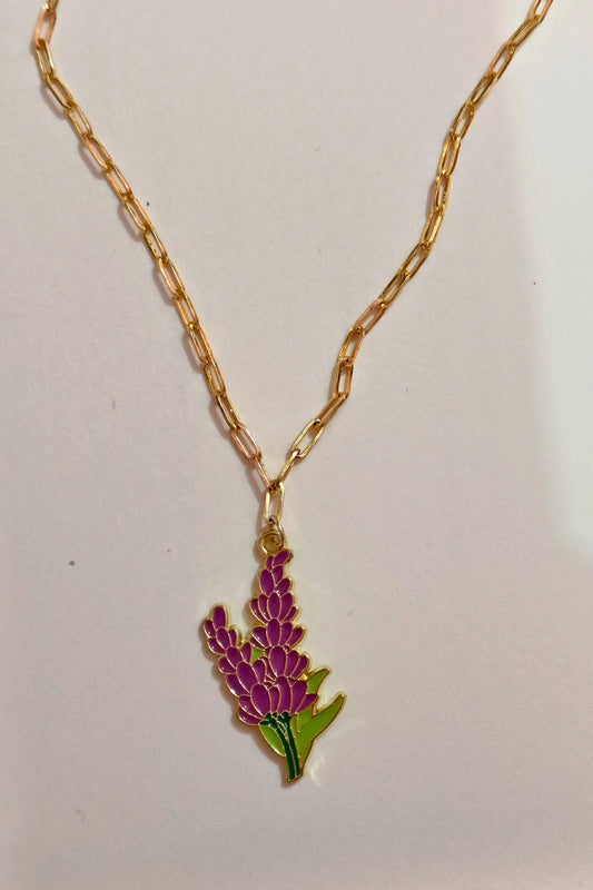 2nd view of a gold chain necklace with a small pendant shaped like a Snapdragon flower.