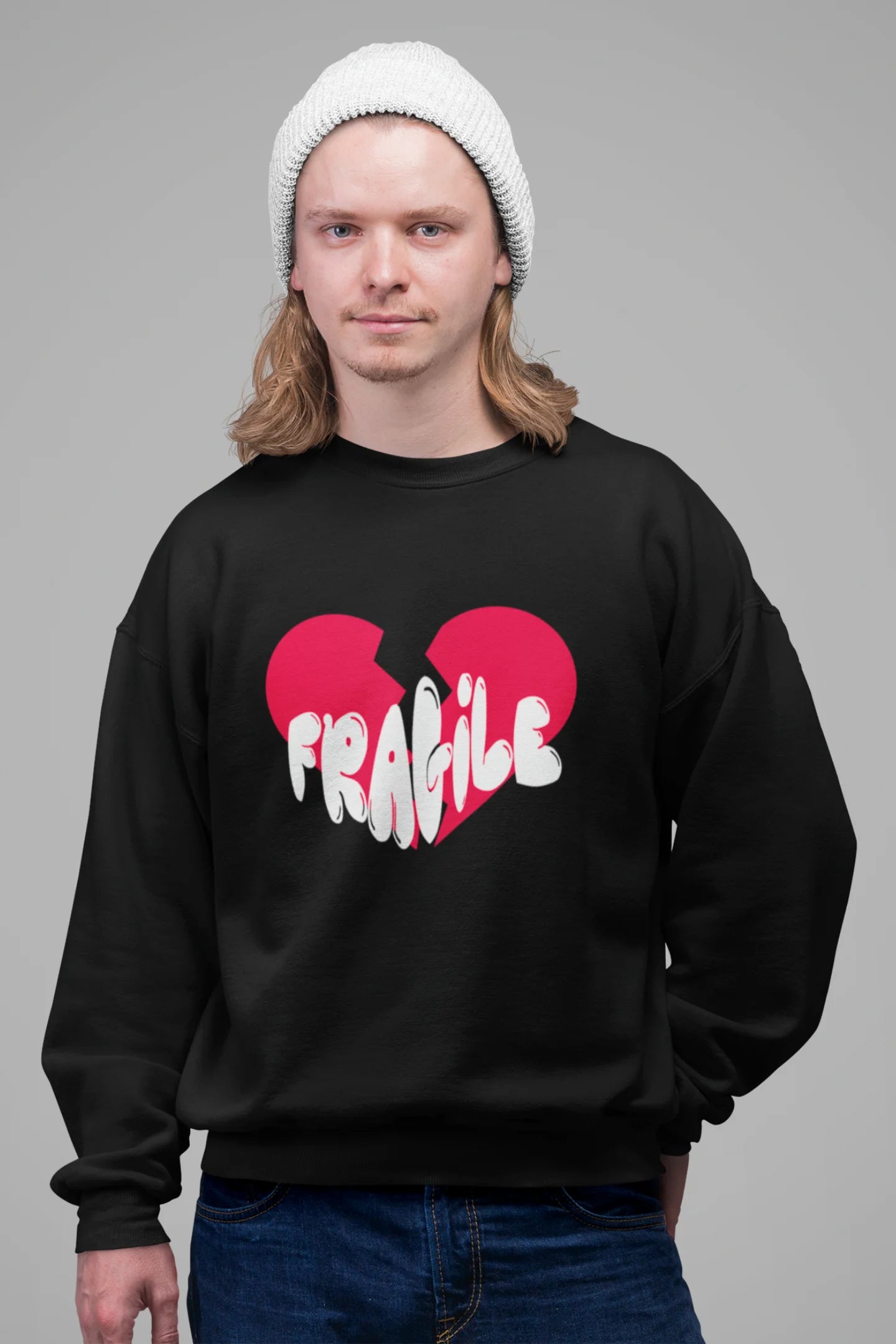 4th front view of a male model wearing a black sweatshirt with a broken heart design and the word "Fragile" in melting text.