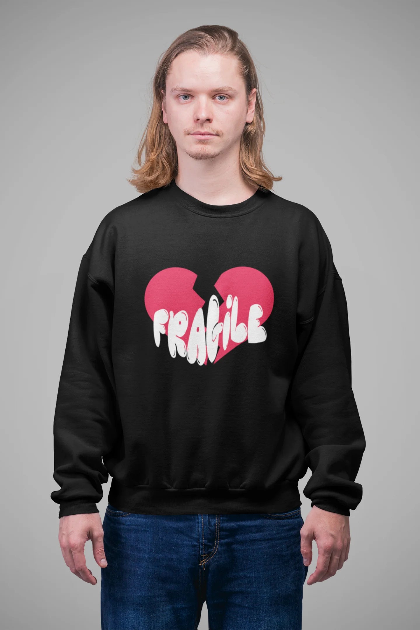 3rd front view of a male model wearing a black sweatshirt with a broken heart design and the word "Fragile" in melting text.