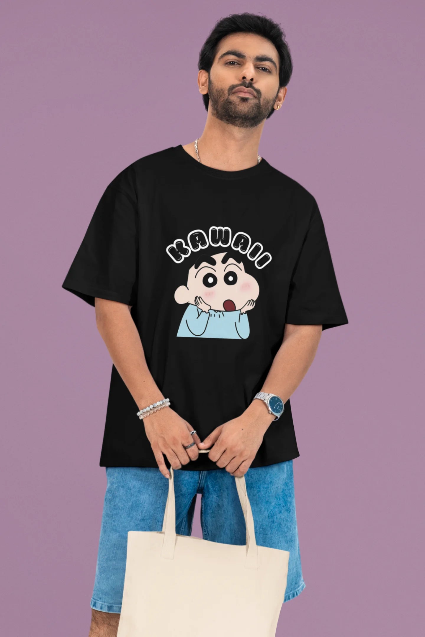 2nd front view of a male model wearin a black oversized t-shirt featuring Shinchan looking amazed and saying "Kawaii."