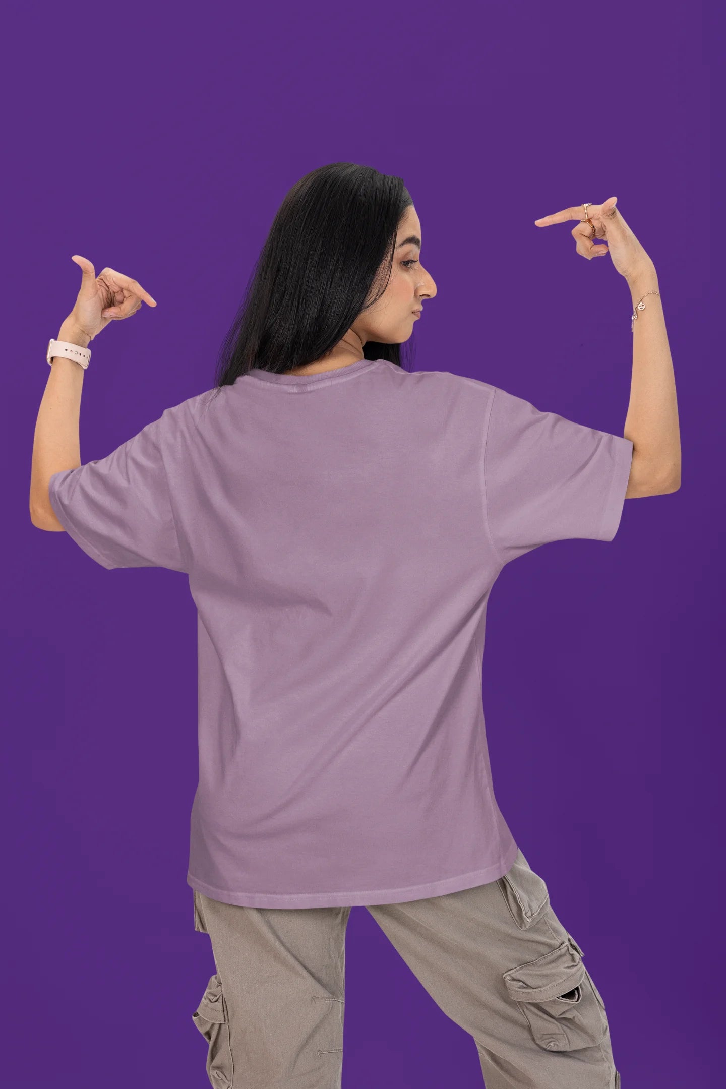 Back image of a female model wearing a dirty purple oversized t-shirt with the text "Cold Outside Like My Heart" and a design of a skeleton drinking champagne.