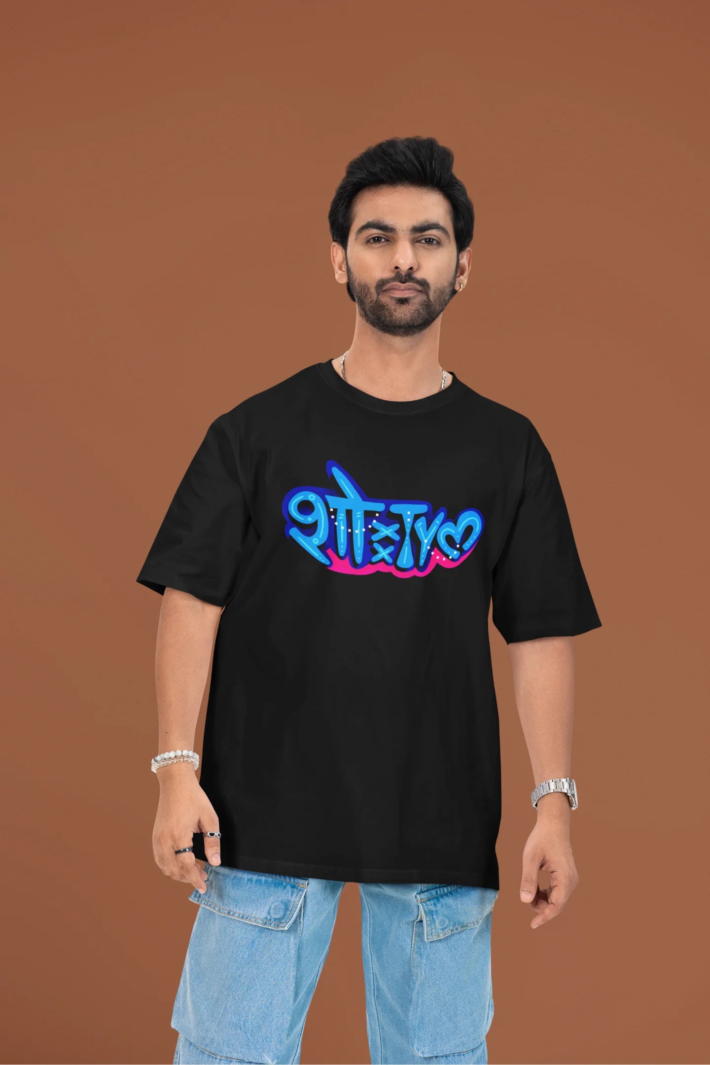 2nd front view of a male model wearing a black oversized t-shirt featuring "Showtime" in Hindi.