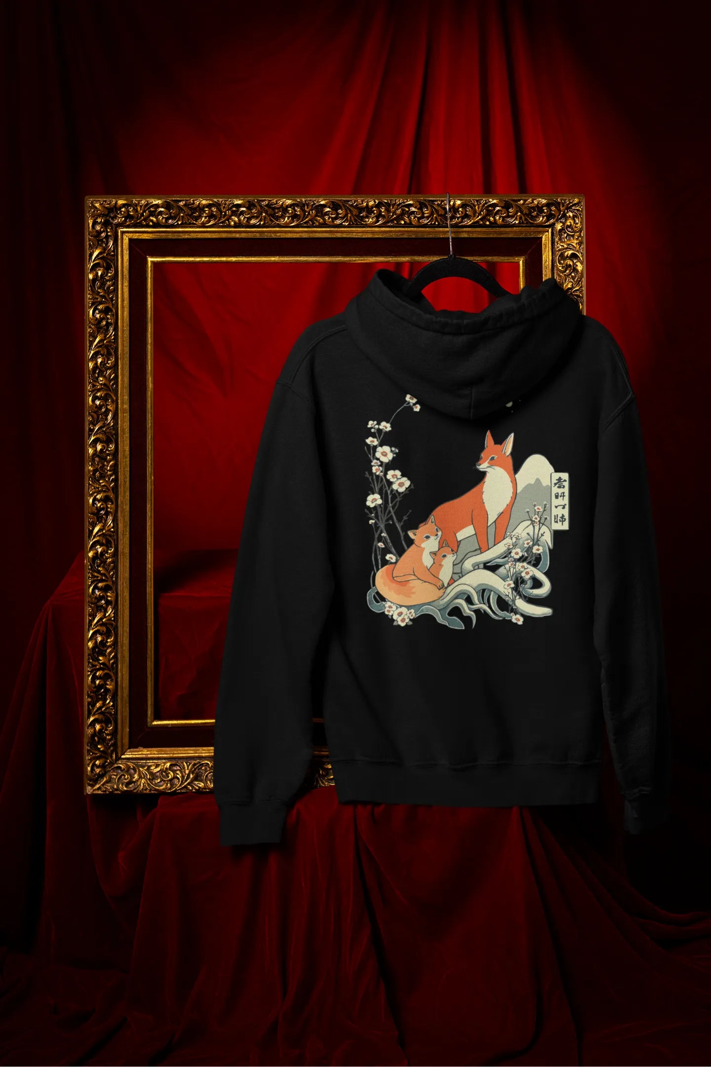 Back view of a black hoodie with a design of a fox and its cub in a traditional Japanese landscape.