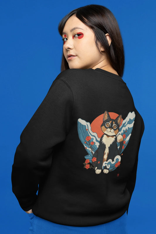 Back view of female model wearing a black sweatshirt with a design of a cat dressed as a samurai, standing against a backdrop of waves and a rising sun.