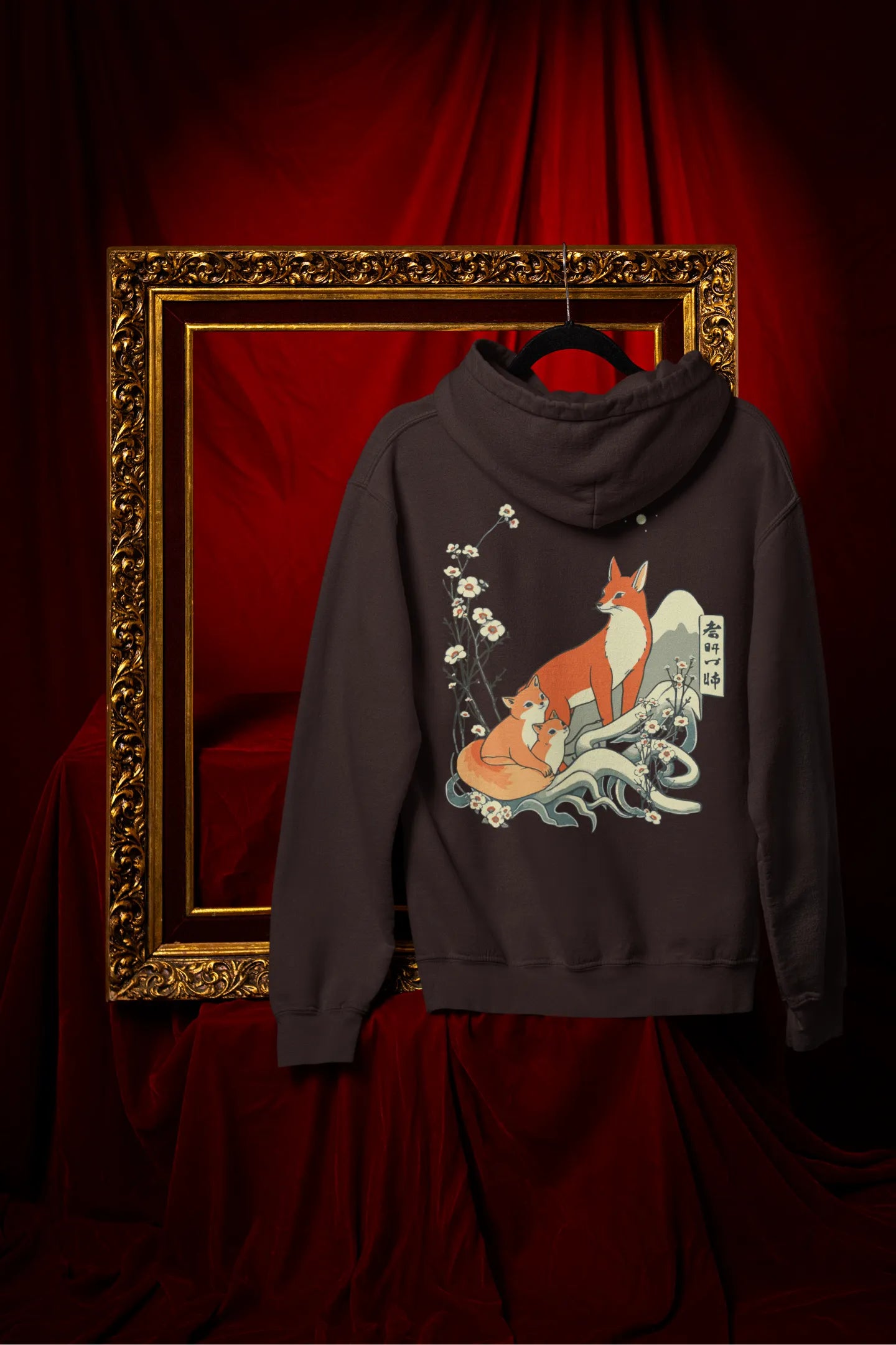Back view of a chocolate brown hoodie with a design of a fox and its cub in a traditional Japanese landscape.