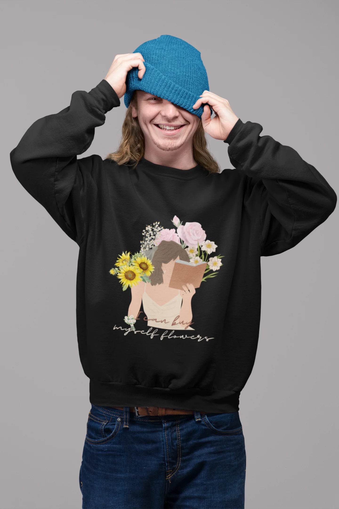 First front view of male model wearing a black sweatshirt with a positive message "Buy Myself Flowers" and a graphic of a smiling woman surrounded by tulips and sunflowers. Ideal for those who love inspirational clothing and floral designs.