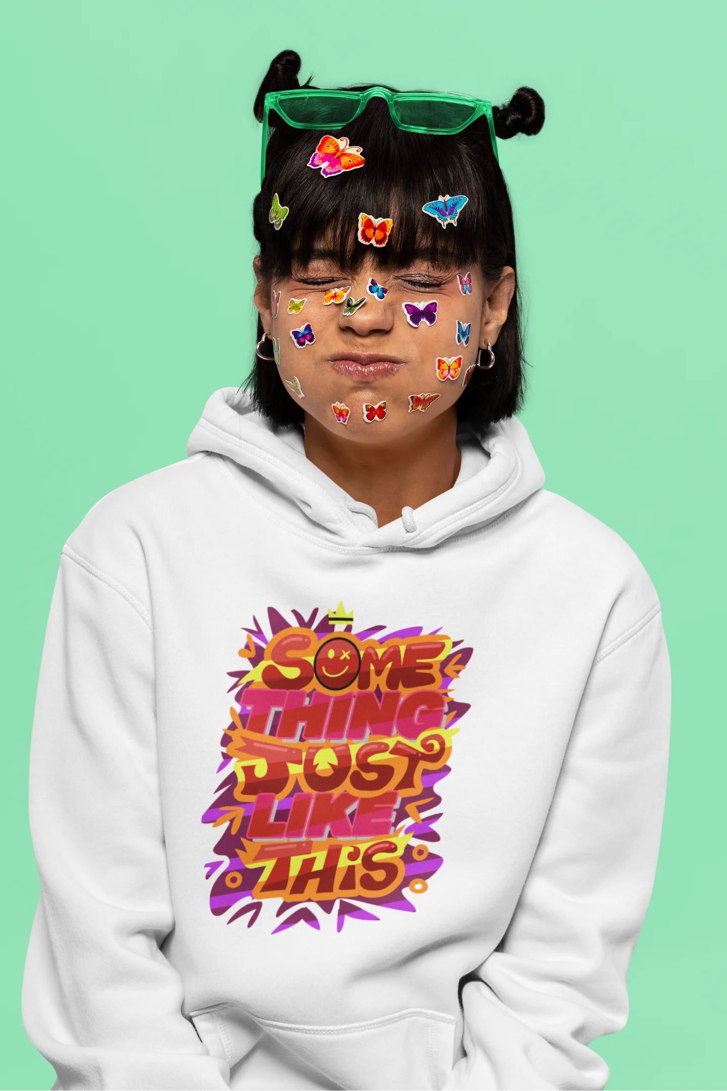 Sixth front view of a female model wearing an off-white hoodie featuring the designs inspired from Coldplay's "Something Just Like This" music video.