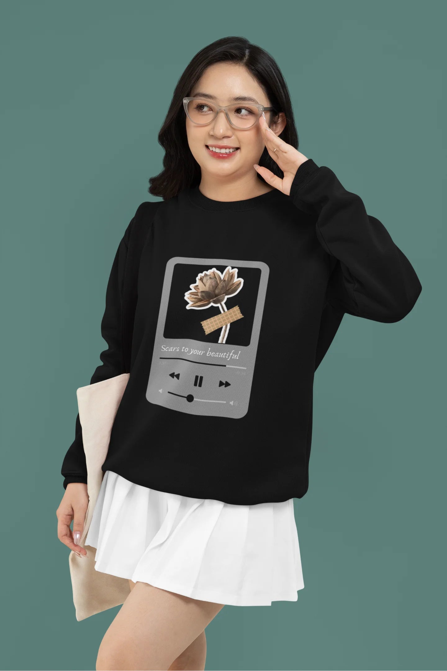 2nd front view of a female model wearing a black sweatshirt featuring a design inspired by Alessia Cara's song "Scars to Your Beautiful." The design includes flowers and a message of self-love. Ideal for fans of Alessia Cara and those who appreciate messages of empowerment.