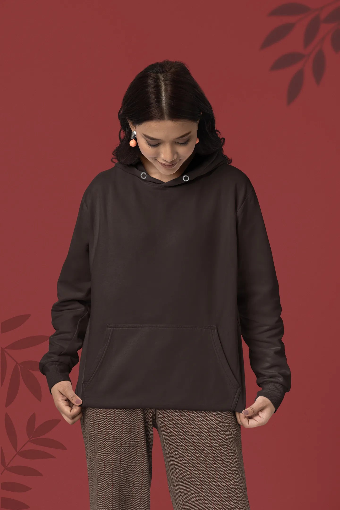 First front view female model wearing a chocolate brown hoodie with a design of a fox and its cub in a traditional Japanese landscape.