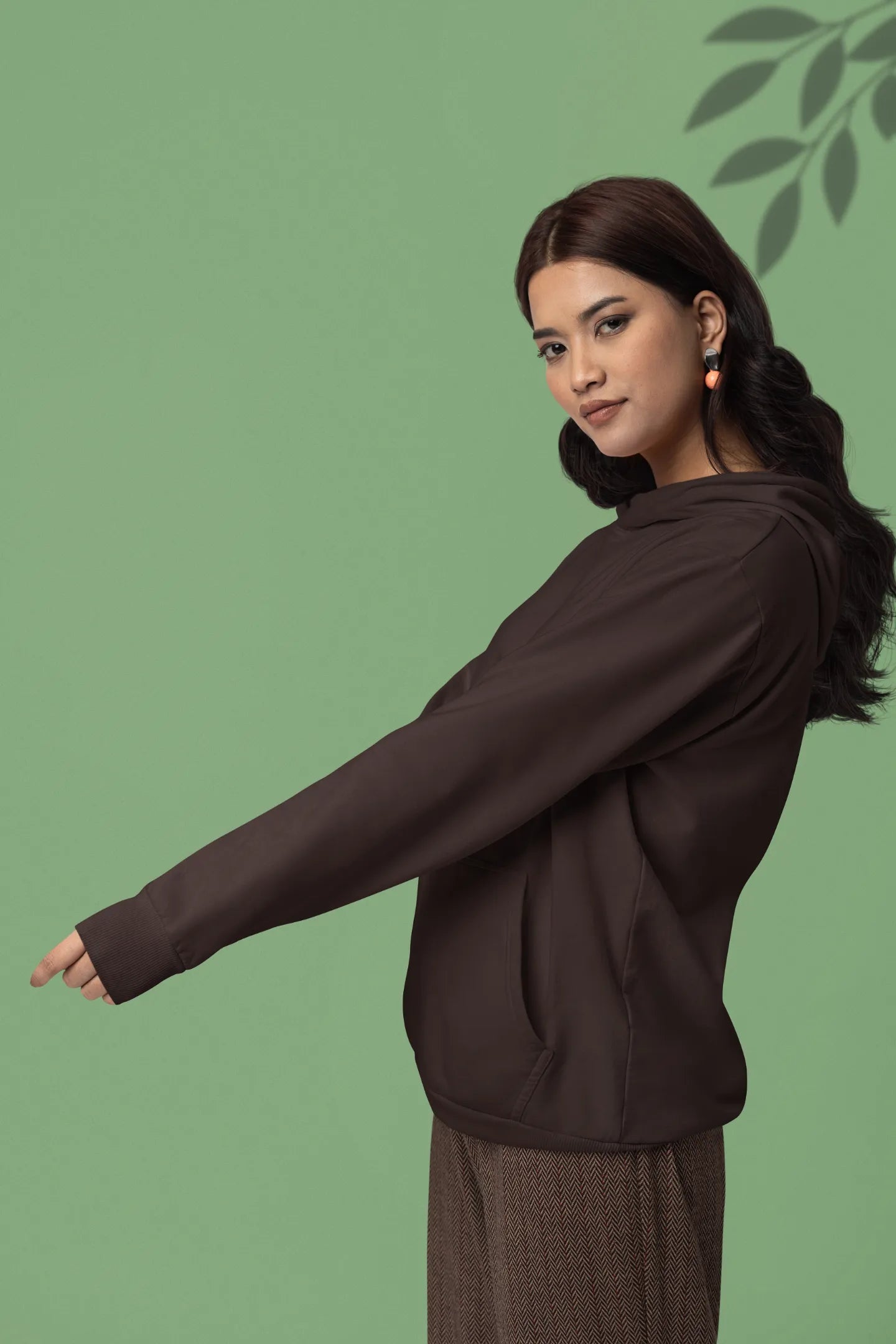 Third front view female model wearing a chocolate brown hoodie with a design of a fox and its cub in a traditional Japanese landscape.
