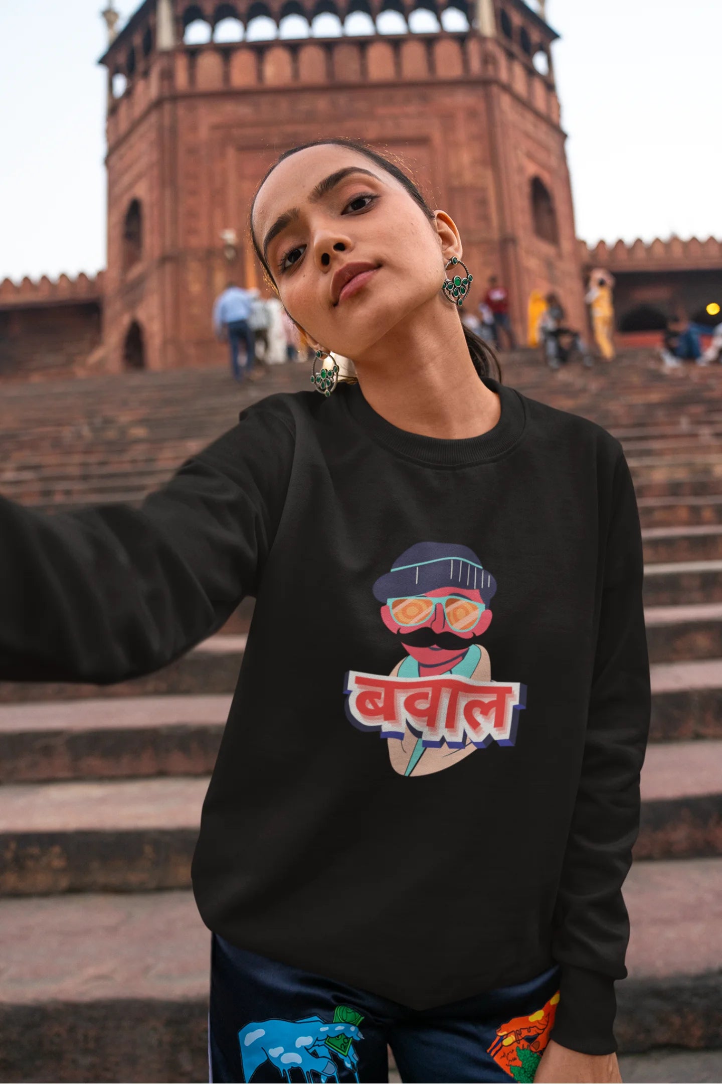 2nd front view of a female model wearing a black oversized t-shirt with "Bawaal" in a stylish Hindi.