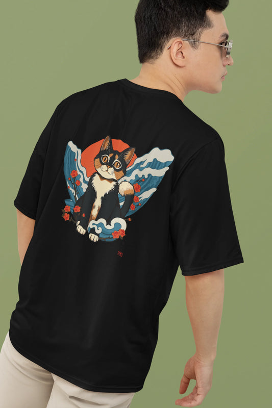 2nd back view of a male model wearing a black oversized tee with a design of a cat dressed as a samurai, standing against a backdrop of waves and a rising sun.