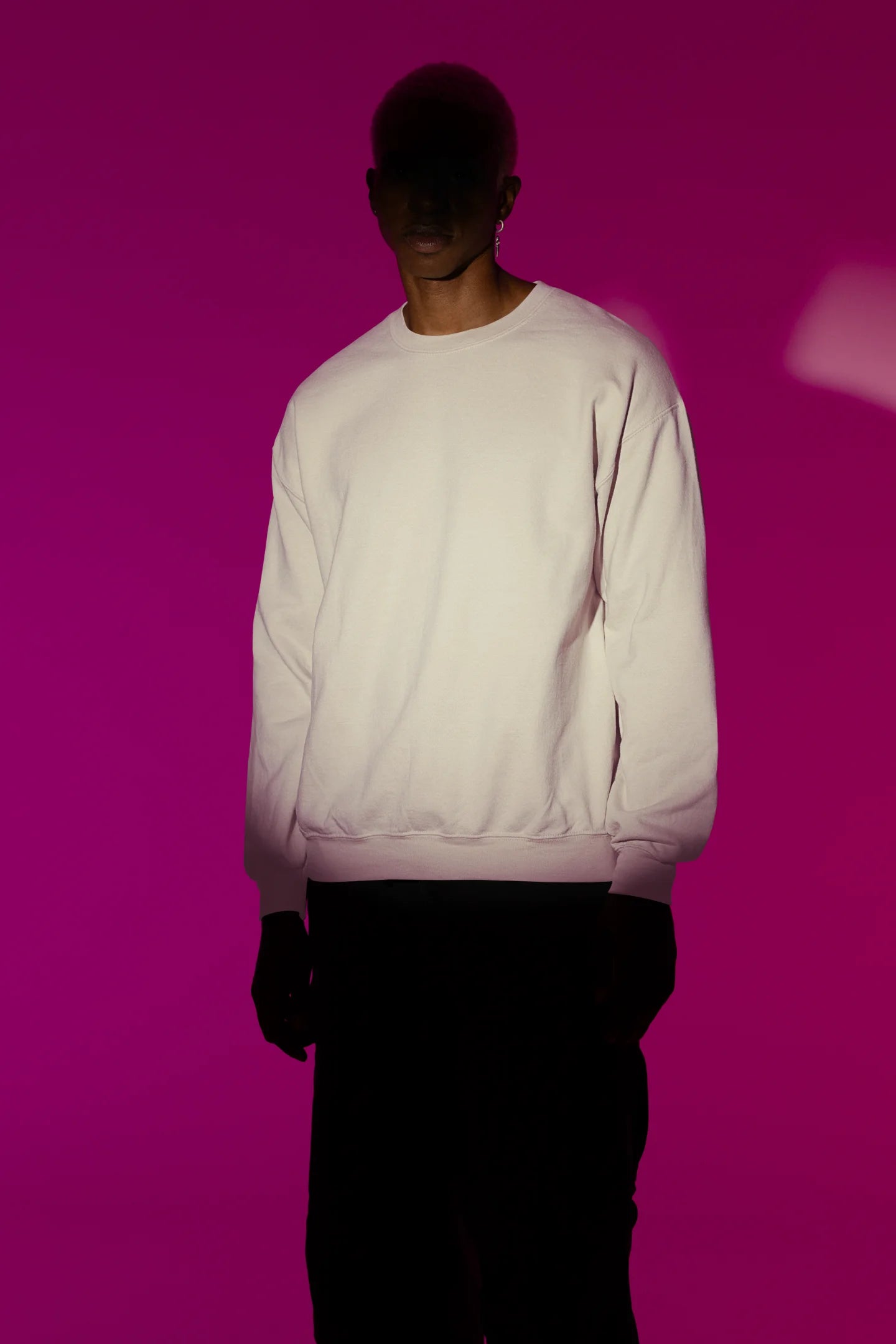 Second front view of male model wearing a cream sweatshirt with a design of a cat dressed as a samurai, standing against a backdrop of waves and a rising sun.