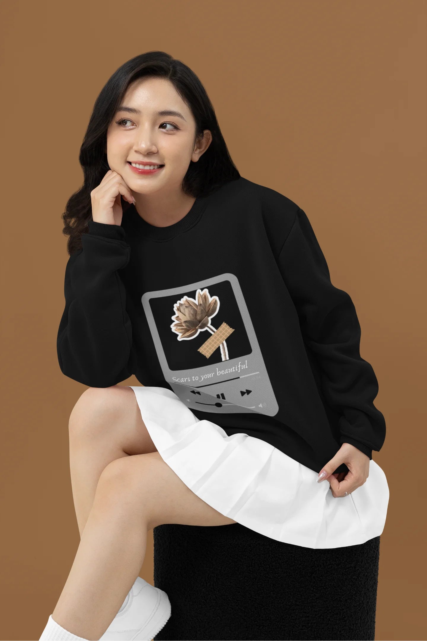 3rd front view of a female model wearing a black sweatshirt featuring a design inspired by Alessia Cara's song "Scars to Your Beautiful." The design includes flowers and a message of self-love. Ideal for fans of Alessia Cara and those who appreciate messages of empowerment.