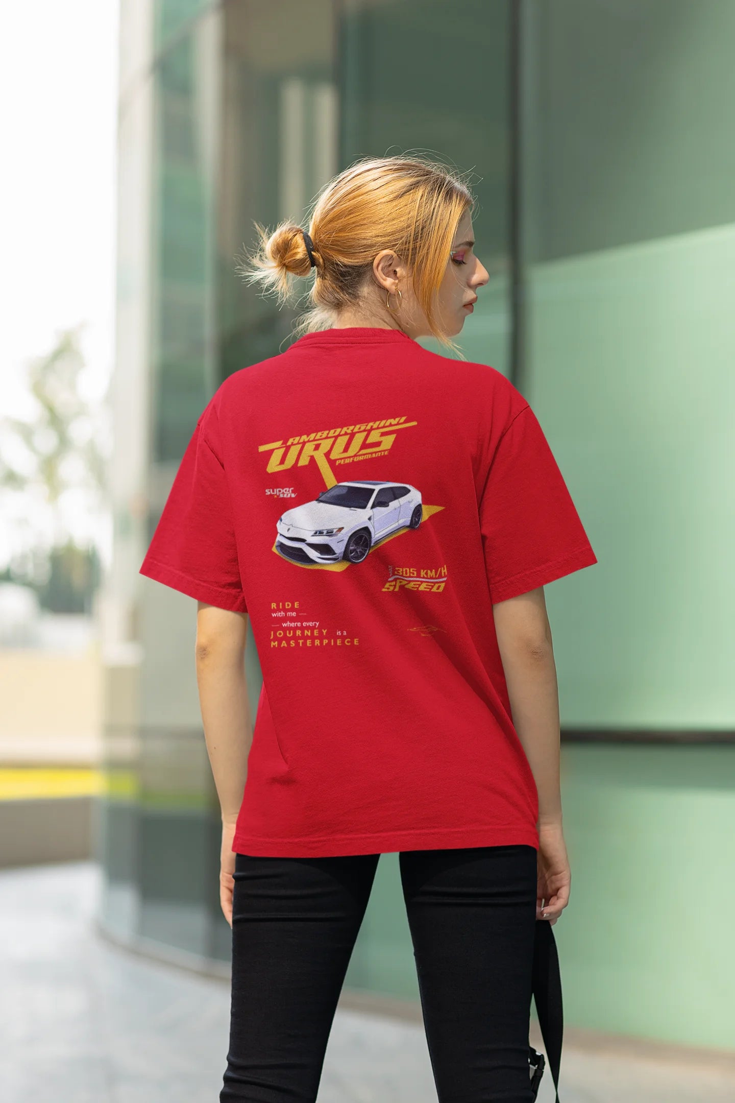 Back view of a female model wearing a red oversized t-shirt featuring a design of a Lamborghini Urus.