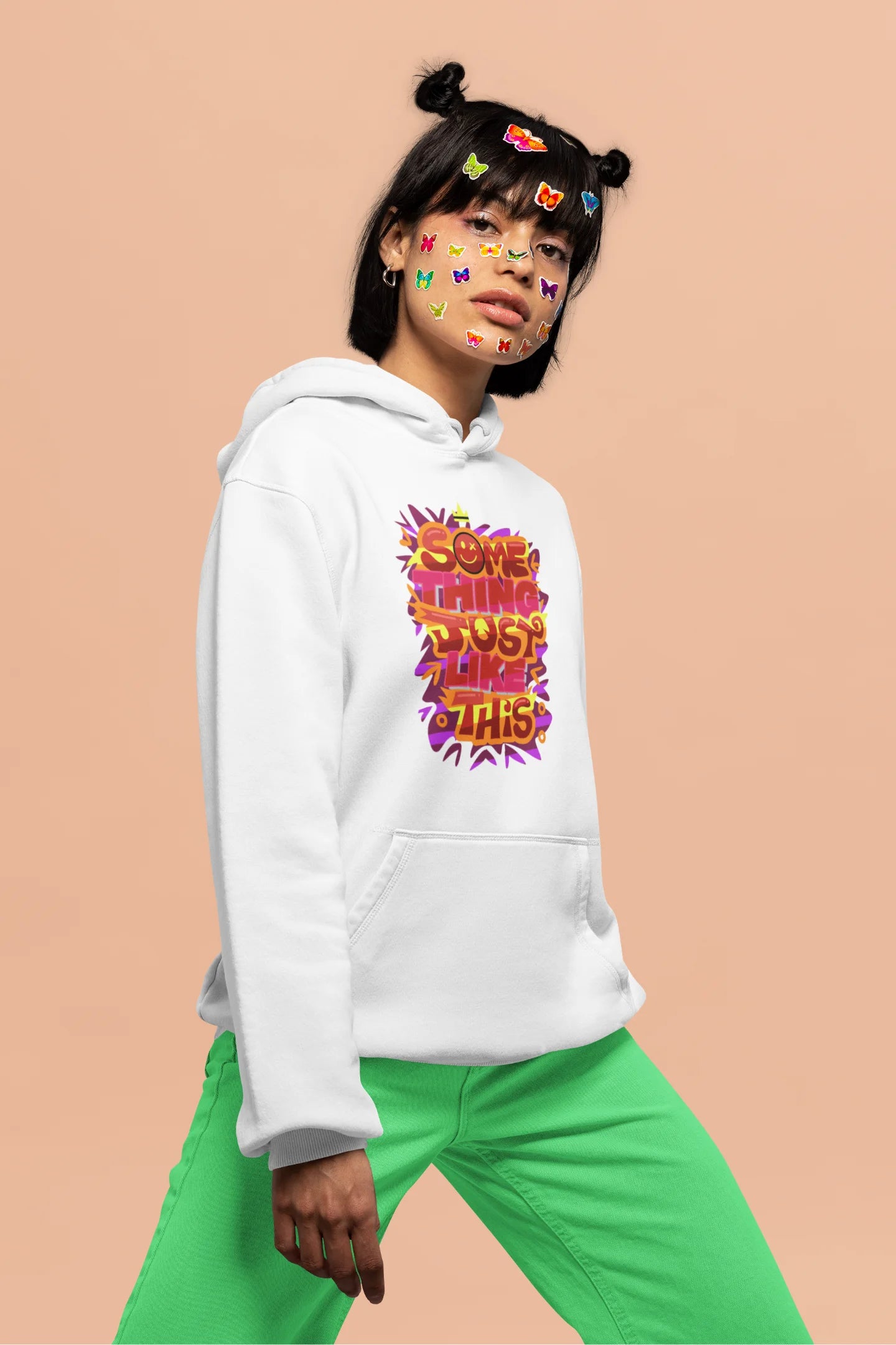 Fourth front view of a female model wearing an off-white hoodie featuring the designs inspired from Coldplay's "Something Just Like This" music video.