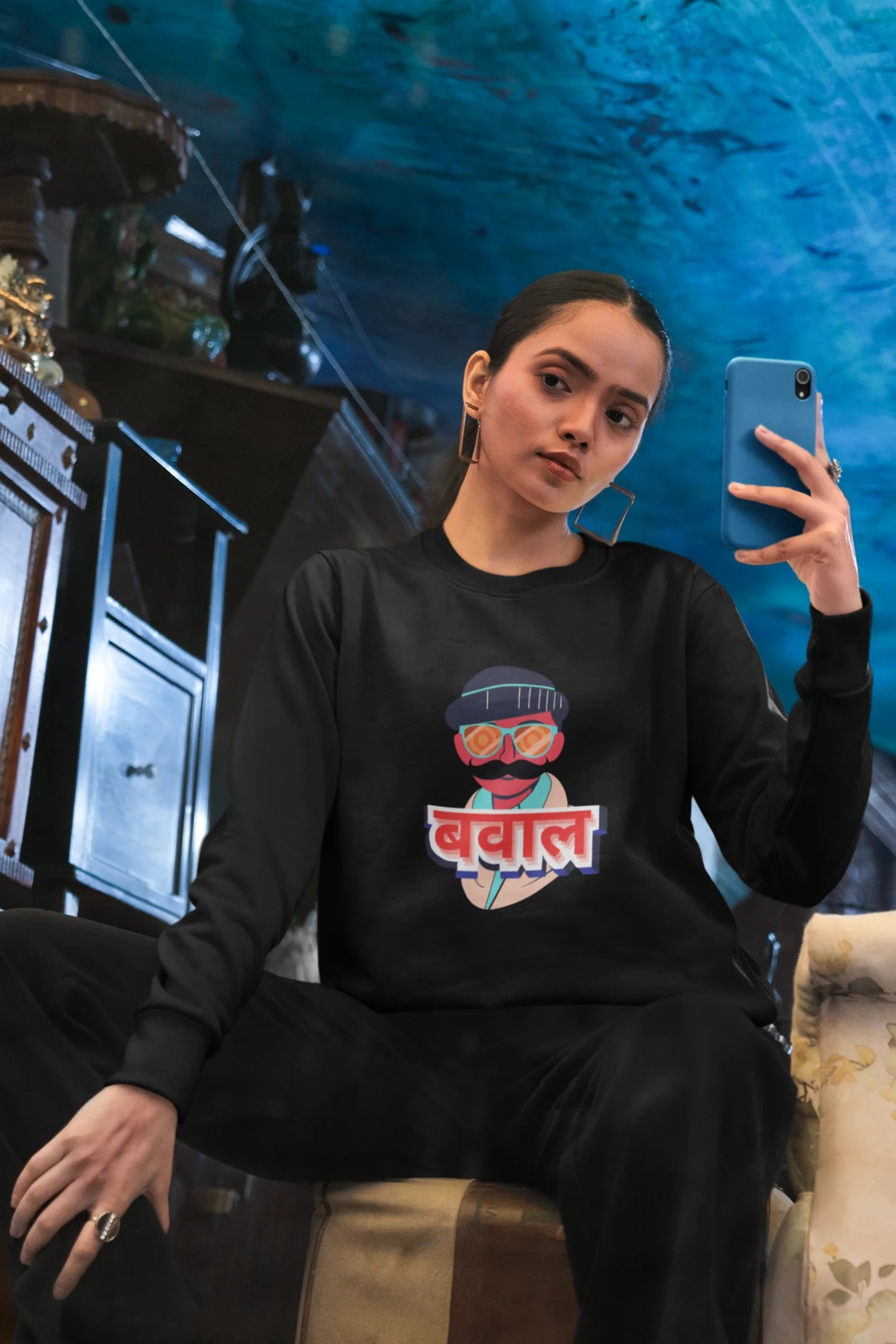 First front view of a female model wearing a black oversized t-shirt with "Bawaal" in a stylish Hindi.