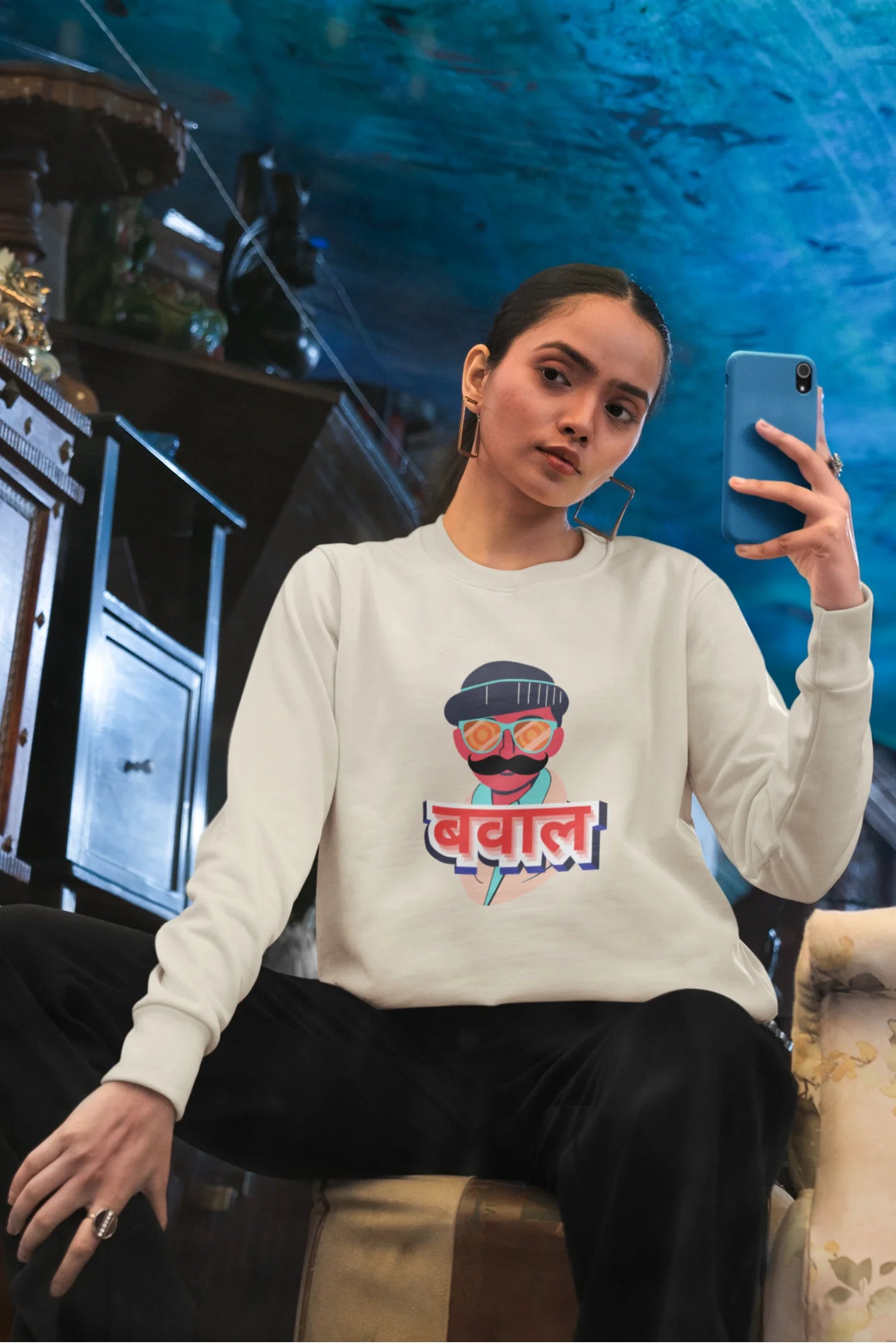First front view of a female model wearing a cream oversized t-shirt with "Bawaal" in a stylish Hindi.