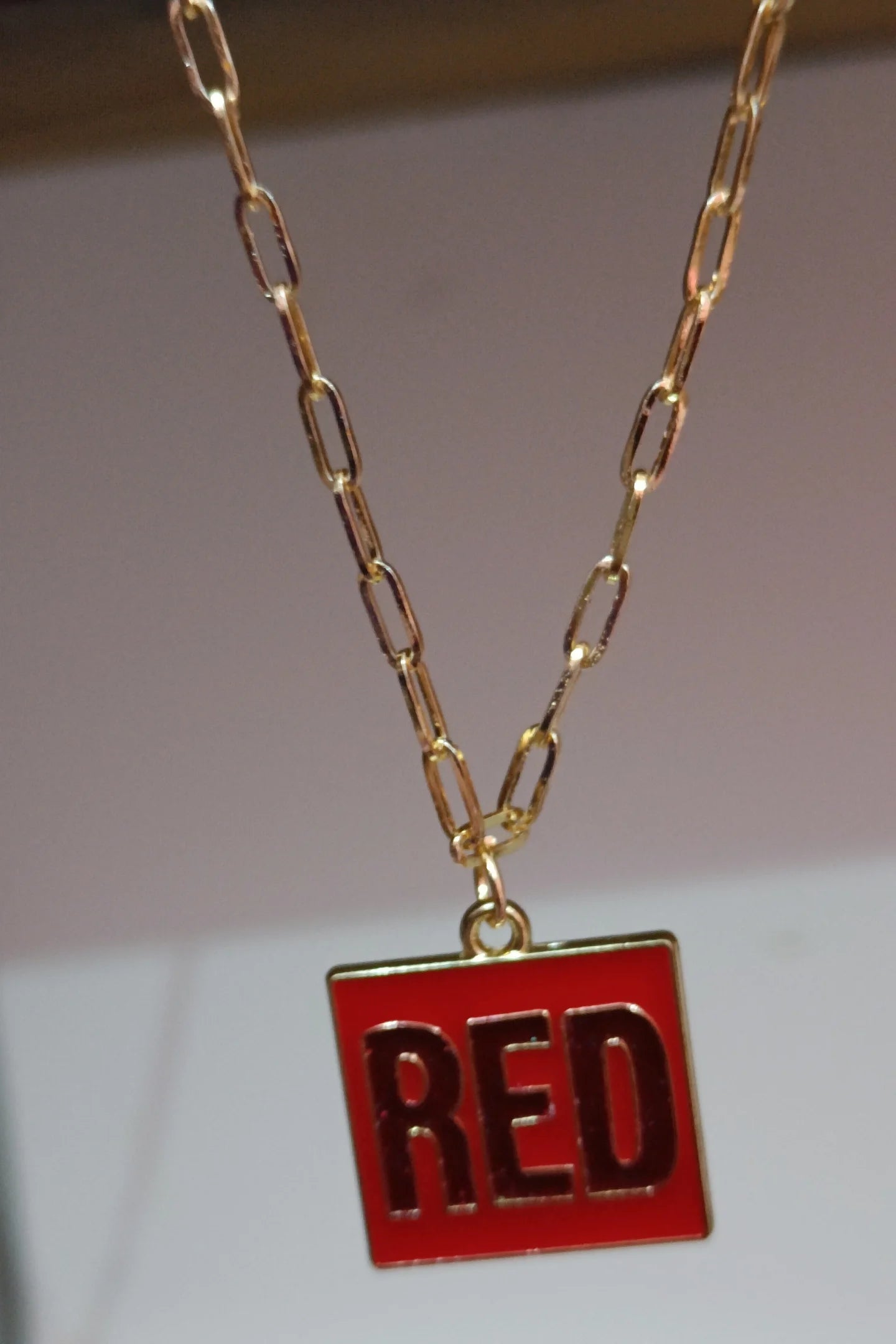Third image of a taylor swift RED era themed anti tarnish gold chain.