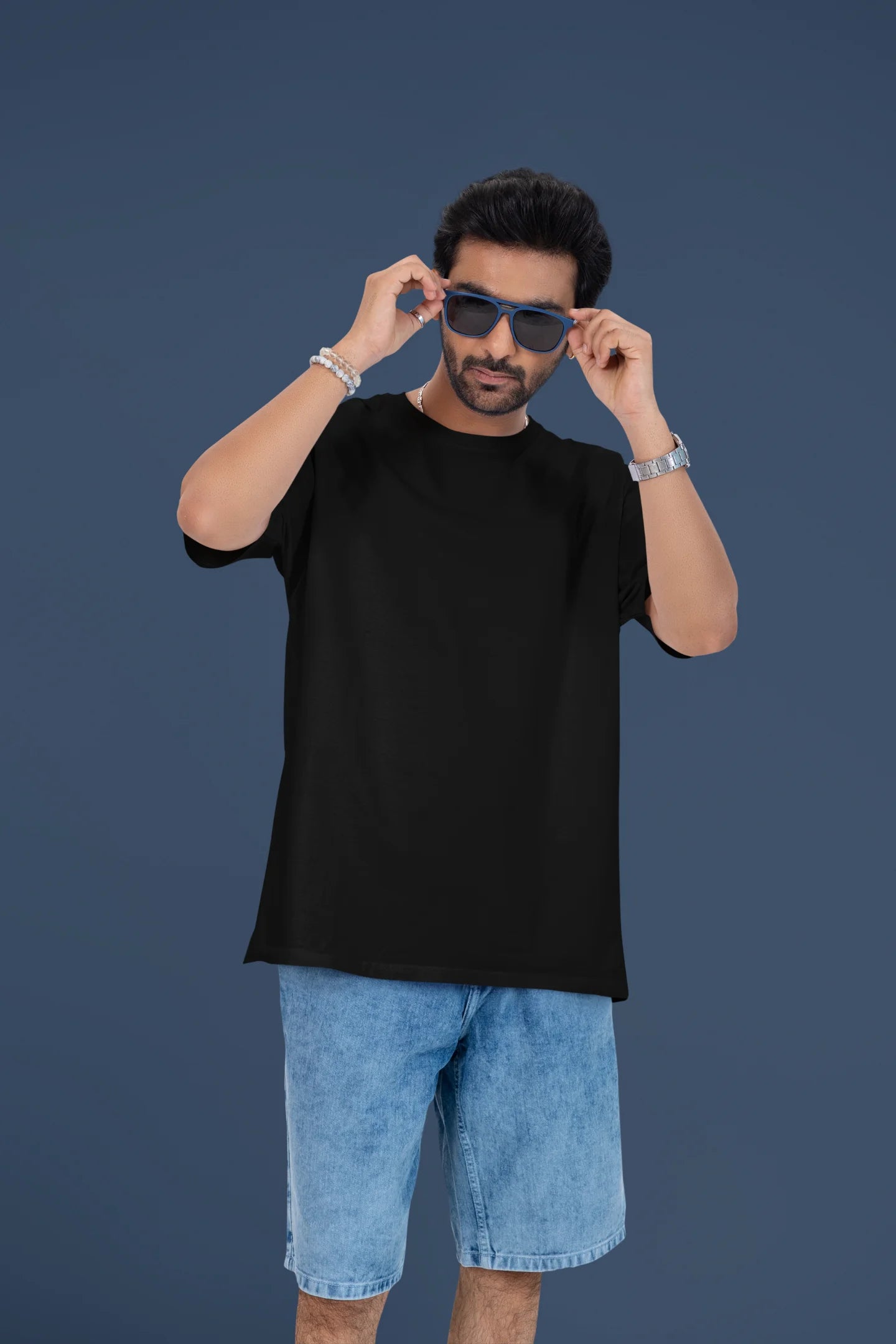 4th front view of a male model wearing a black oversized t-shirt featuring a romantic scene of a couple by a lamppost, inspired by Ed Sheeran's "Beautiful People."