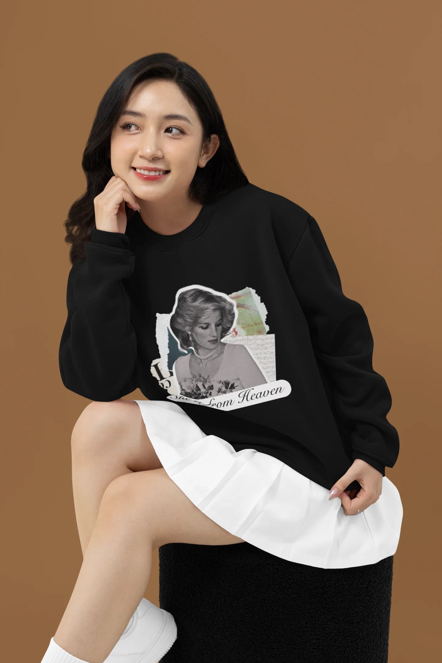 3rd front view of female model wearing a black sweatshirt featuring a black and white photo of Princess Diana with the text "She is from Heaven." Ideal for fans of Princess Diana and those who want to celebrate a royal icon.