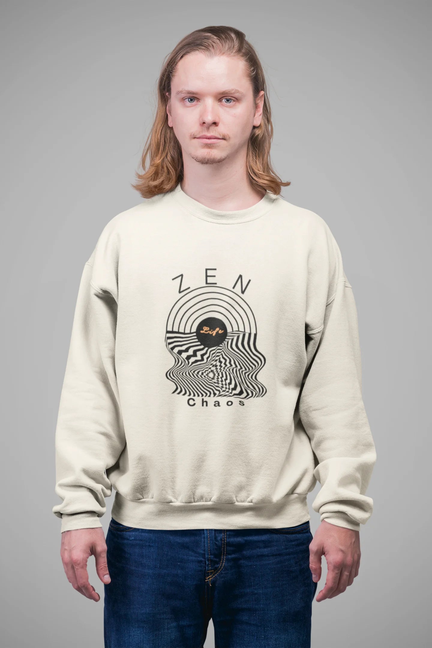 3rd front view of a male model wearing an cream sweatshirt featuring an aesthetic design of a setting sun and crashing waves with the text "Zen & Chaos" above it. Ideal for those who love philosophical themes and visually striking clothing.