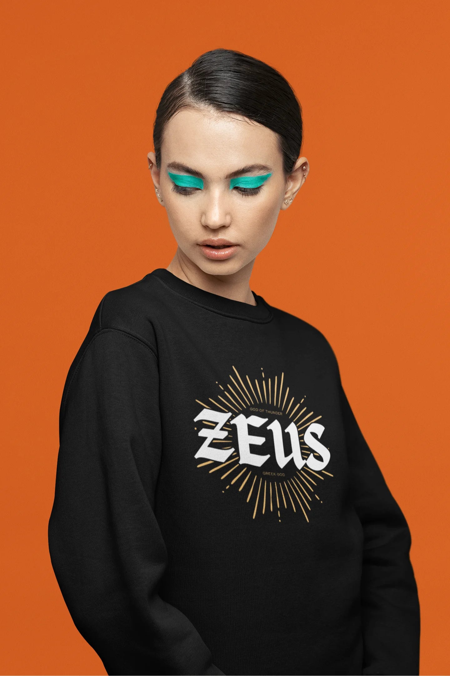 Fifth front view of a female model wearing a brutalist-inspired black sweatshirt with a stylized image of Zeus, king of the gods, in a concrete-like design.