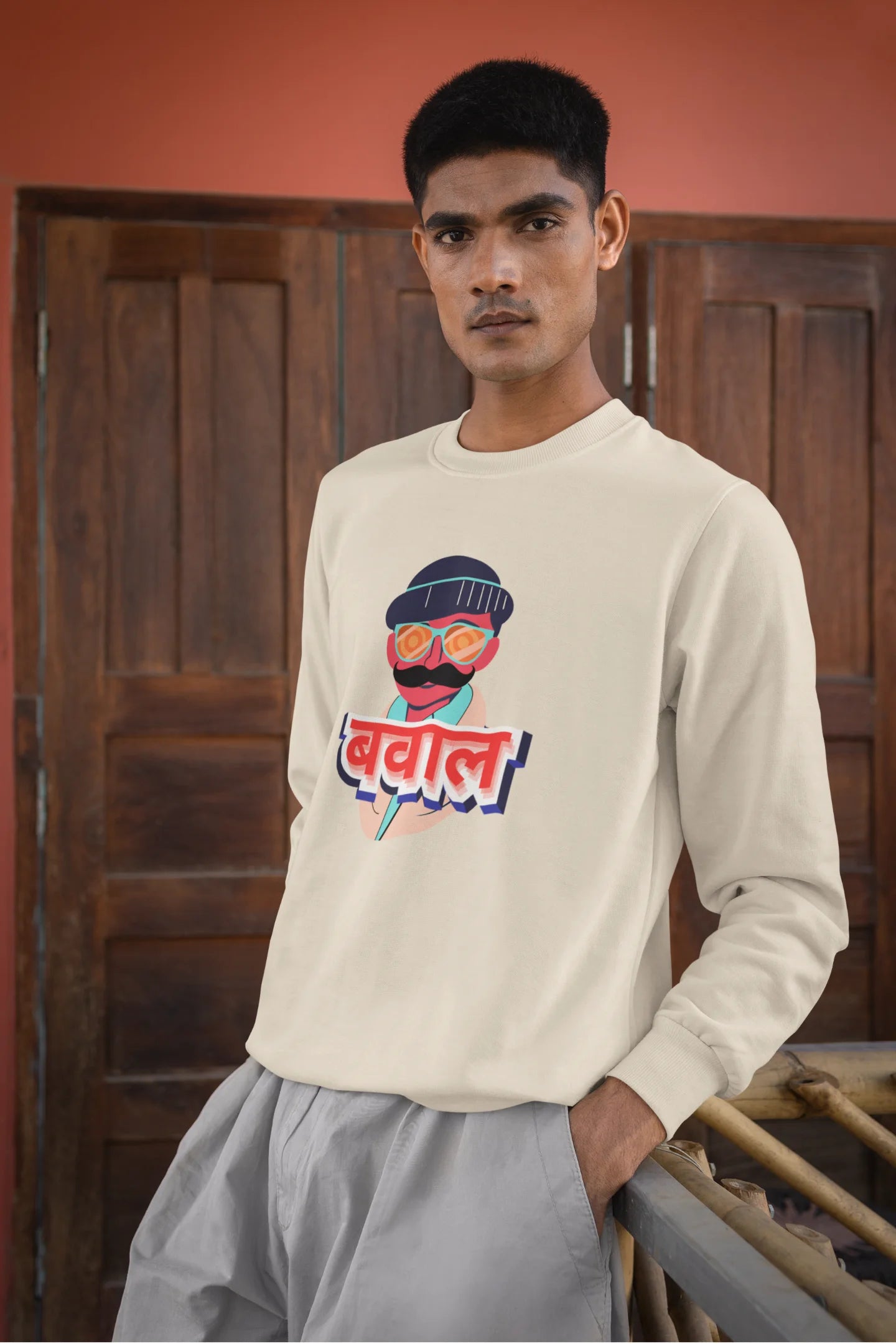 3rd front view of a male model wearing a cream oversized t-shirt with "Bawaal" in a stylish Hindi.