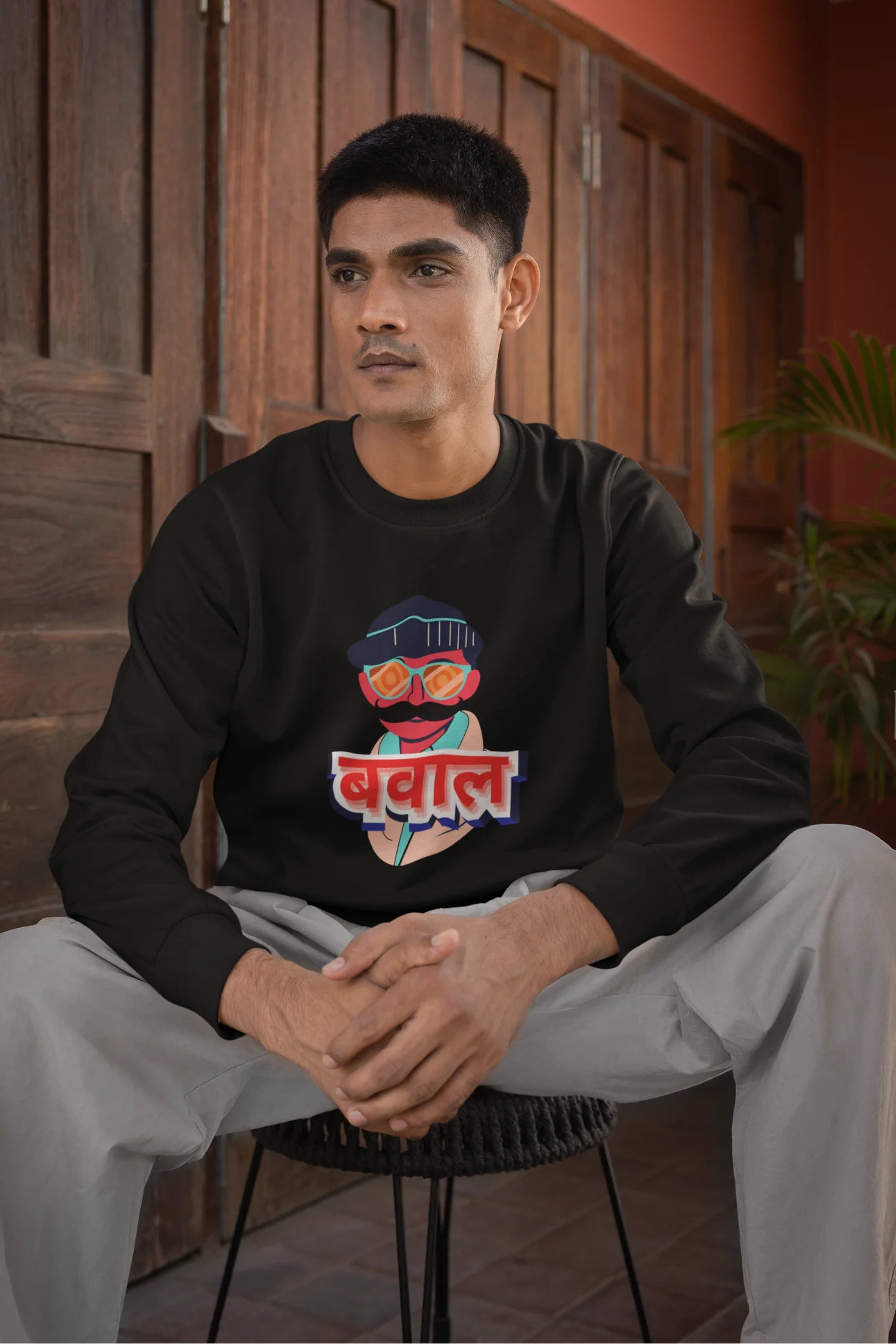 First front view of a male model wearing a black oversized t-shirt with "Bawaal" in a stylish Hindi.