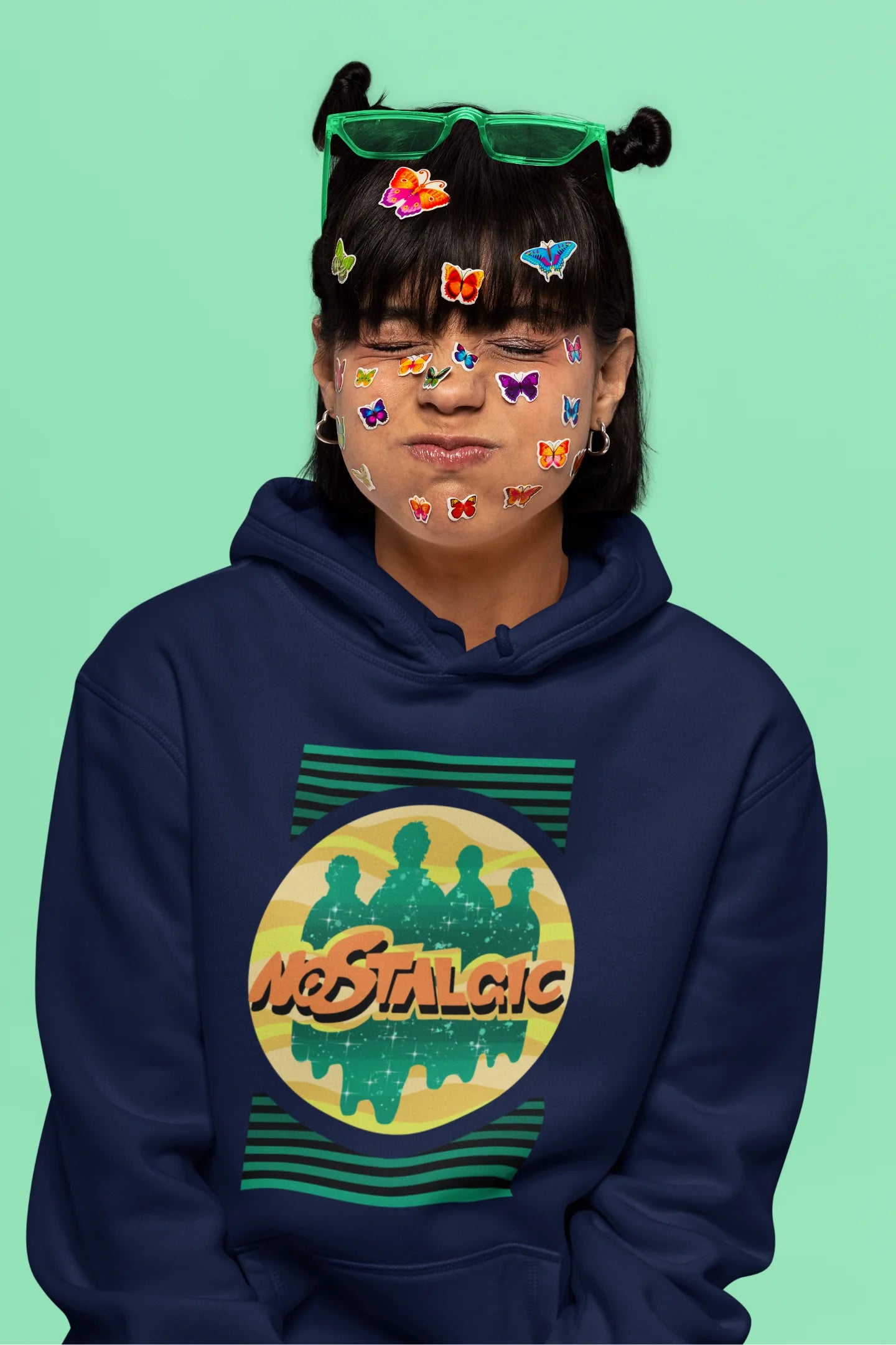 6th front view of a female model wearing an navy blue hoodie with a shadow silhouette of the Coldplay band members and the word "Nostalgic" printed on it.