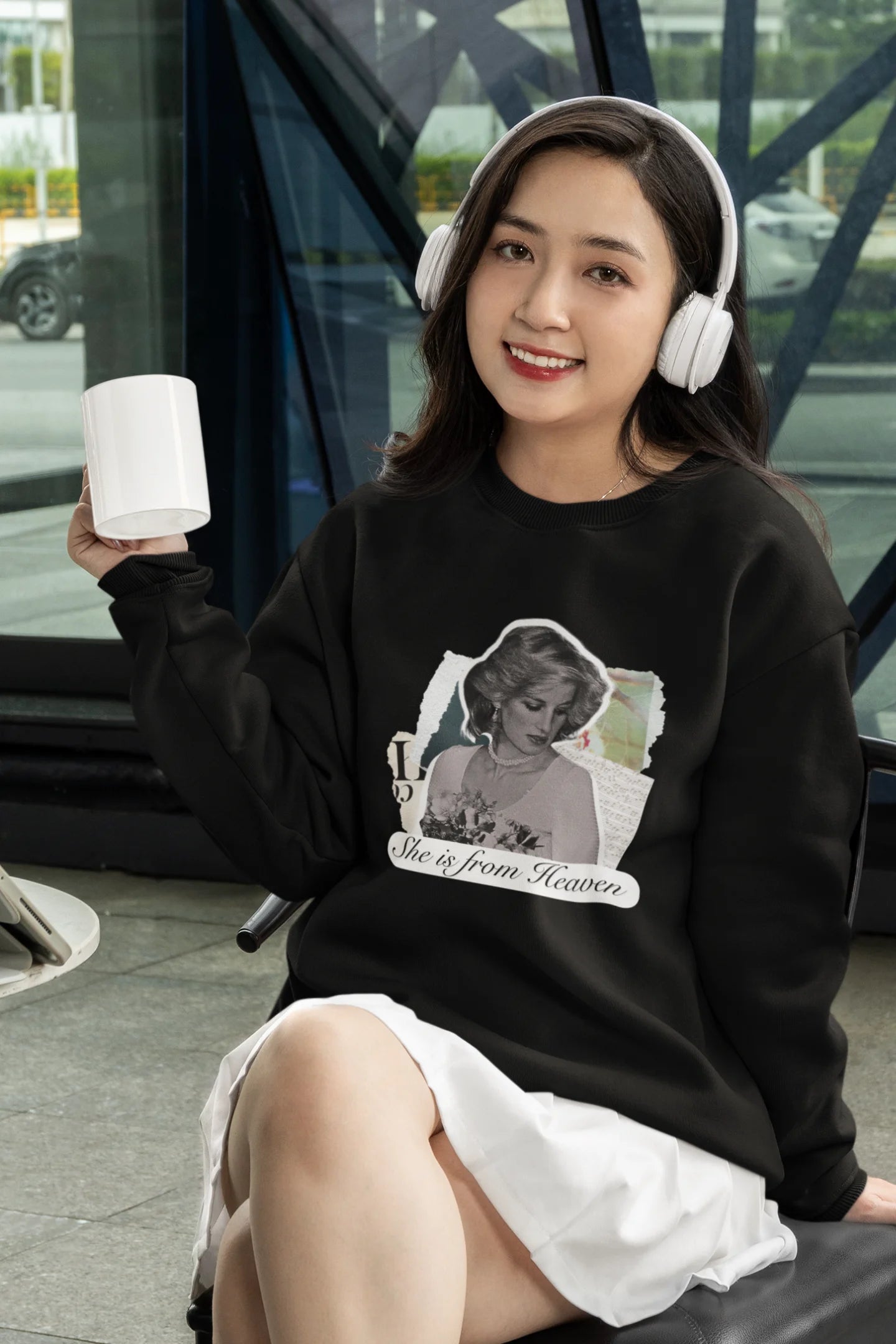 First front view of female model wearing a black sweatshirt featuring a black and white photo of Princess Diana with the text "She is from Heaven." Ideal for fans of Princess Diana and those who want to celebrate a royal icon.