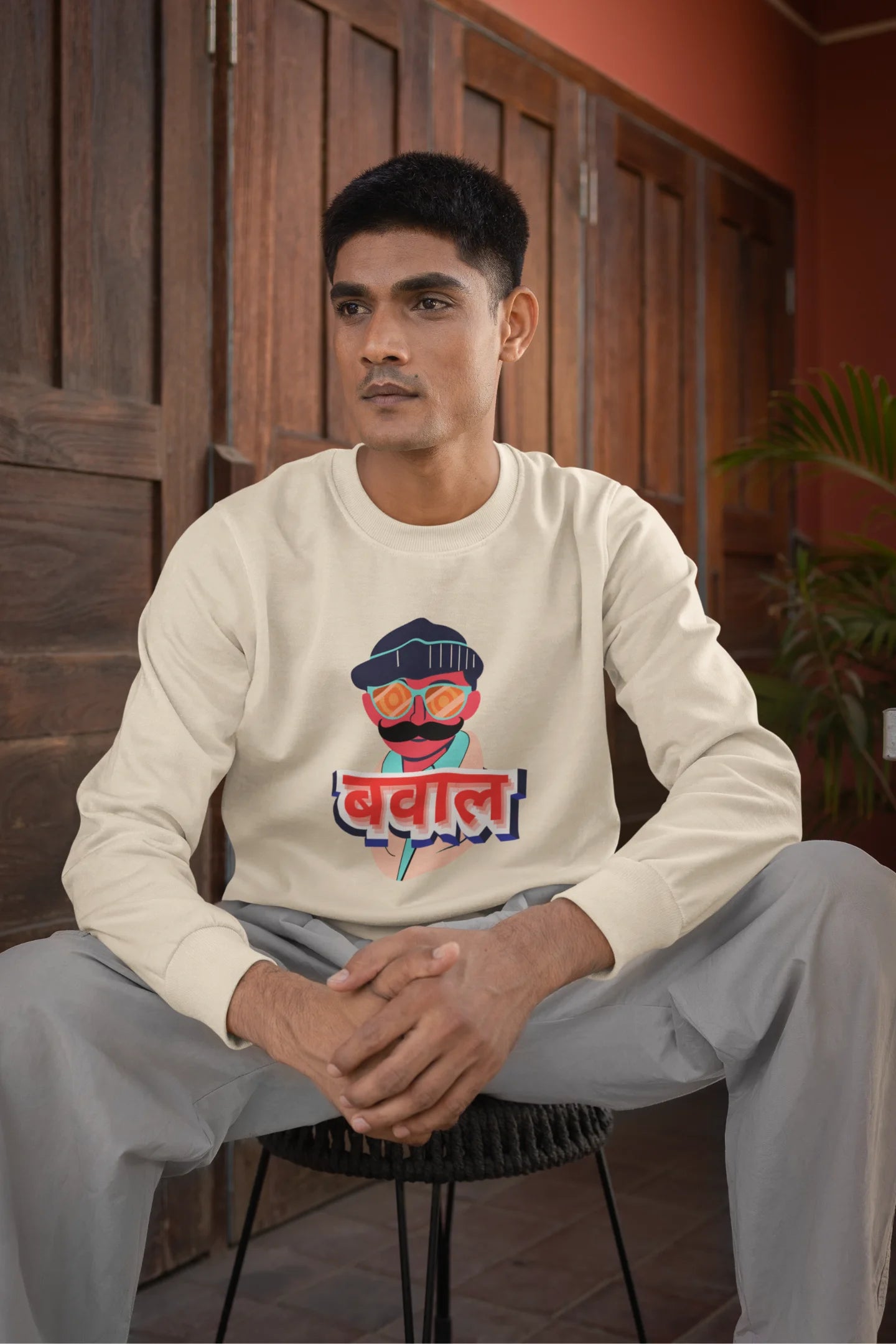 First front view of a male model wearing a cream oversized t-shirt with "Bawaal" in a stylish Hindi.