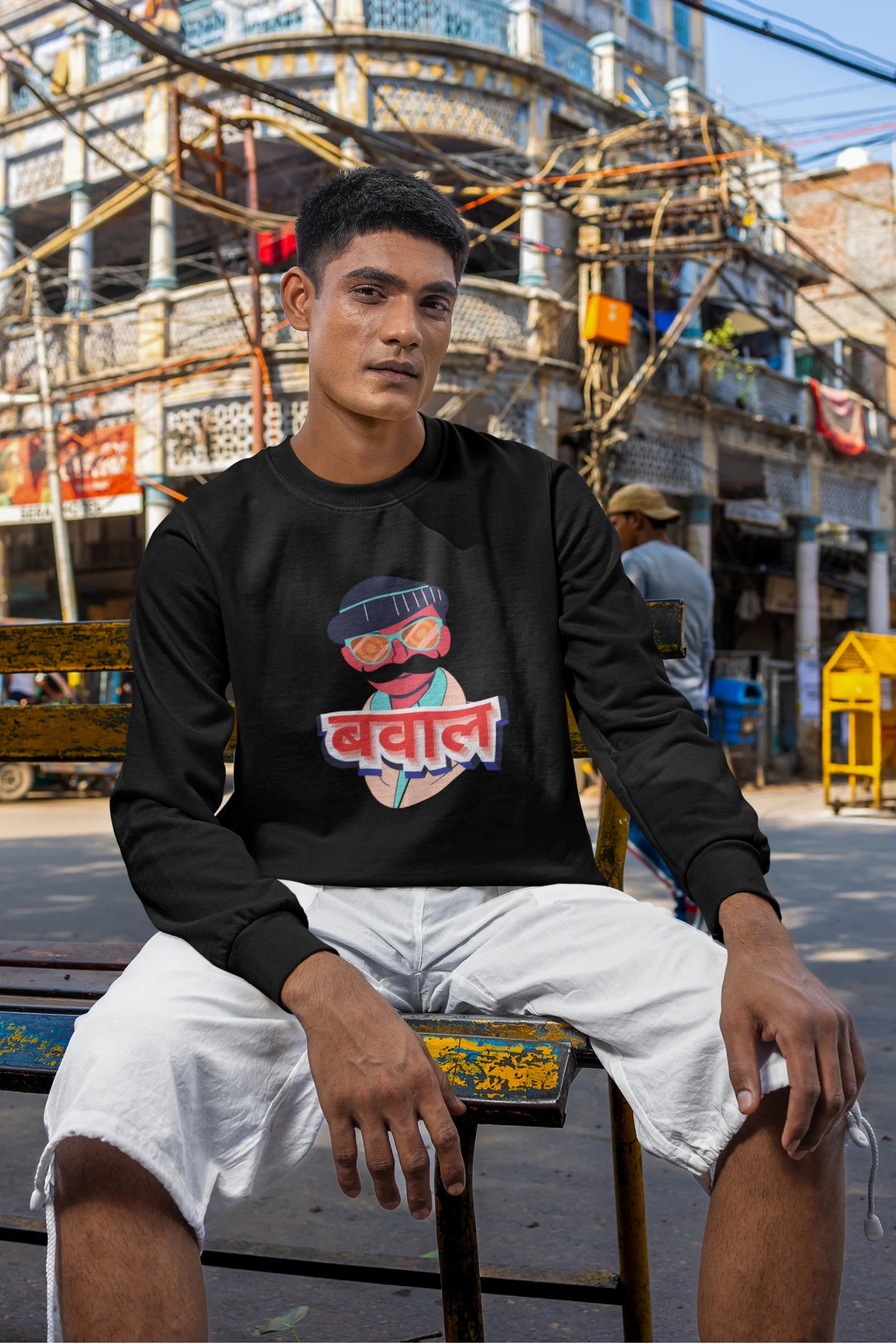 3rd front view of a male model wearing a black oversized t-shirt with "Bawaal" in a stylish Hindi.