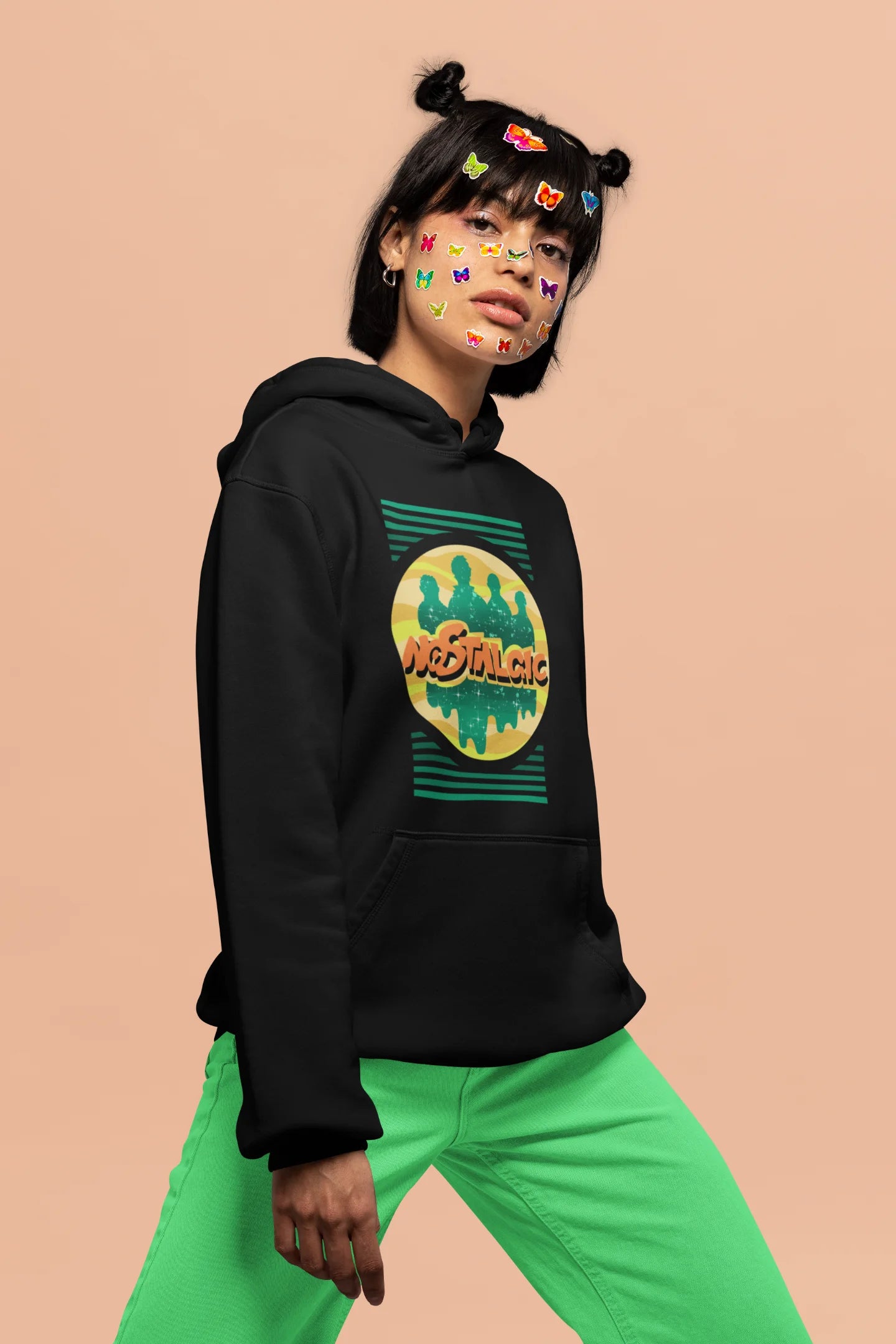 3rd front view of a female model wearing an black hoodie with a shadow silhouette of the Coldplay band members and the word "Nostalgic" printed on it.