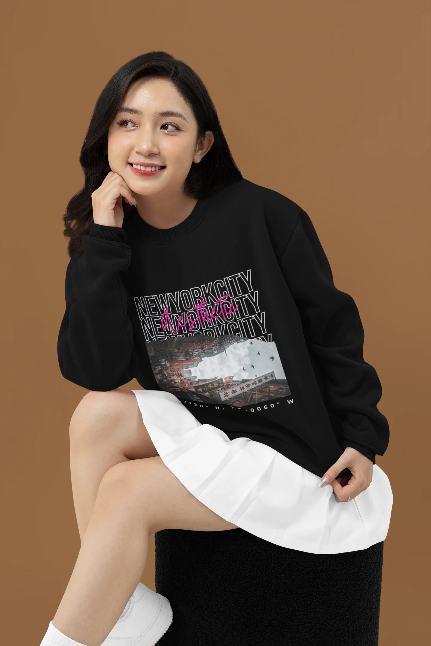 2nd front view of a female model wearing a black sweatshirt with a New York City skyline design, offering a relaxed urban aesthetic.