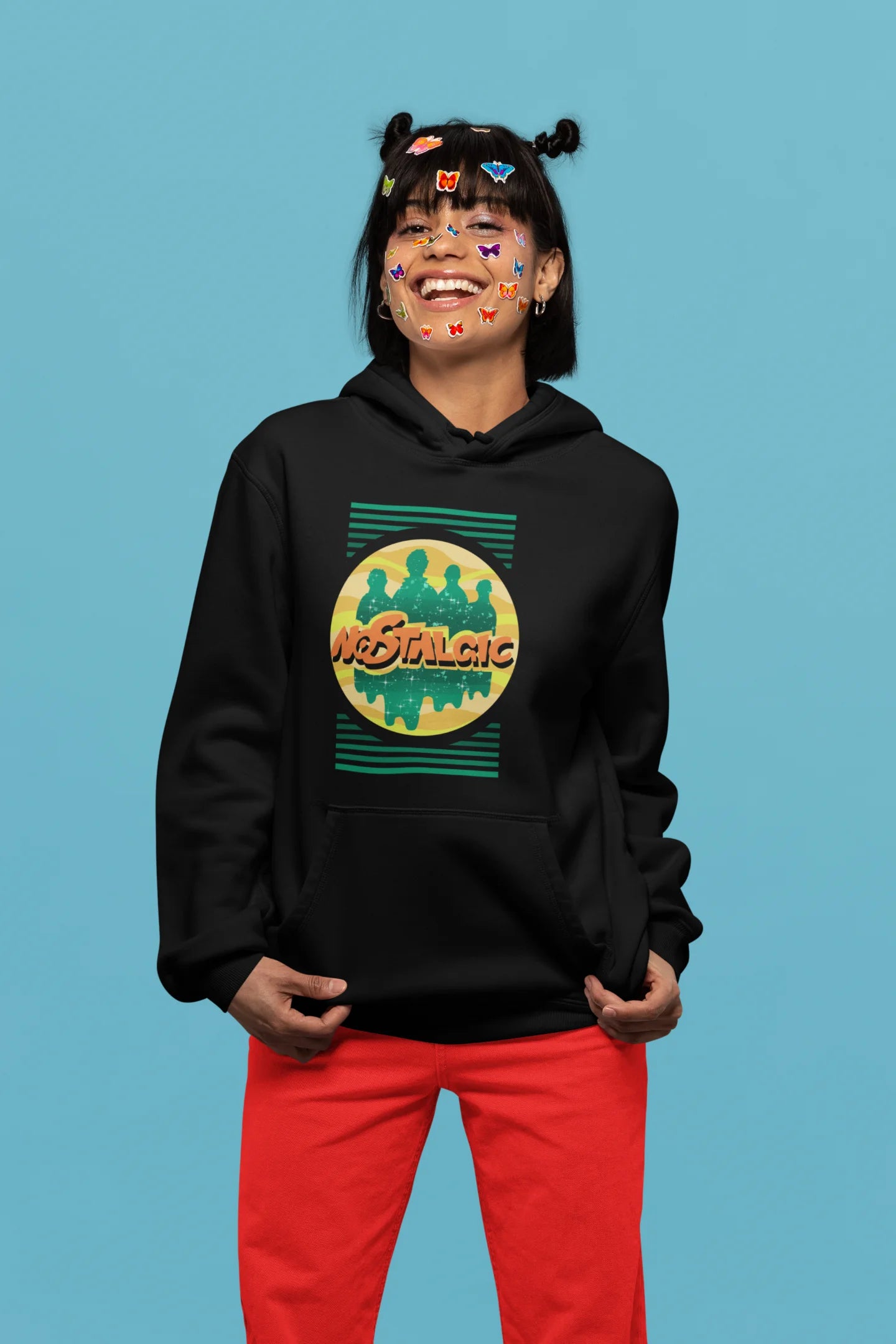 4th front view of a female model wearing an black hoodie with a shadow silhouette of the Coldplay band members and the word "Nostalgic" printed on it.