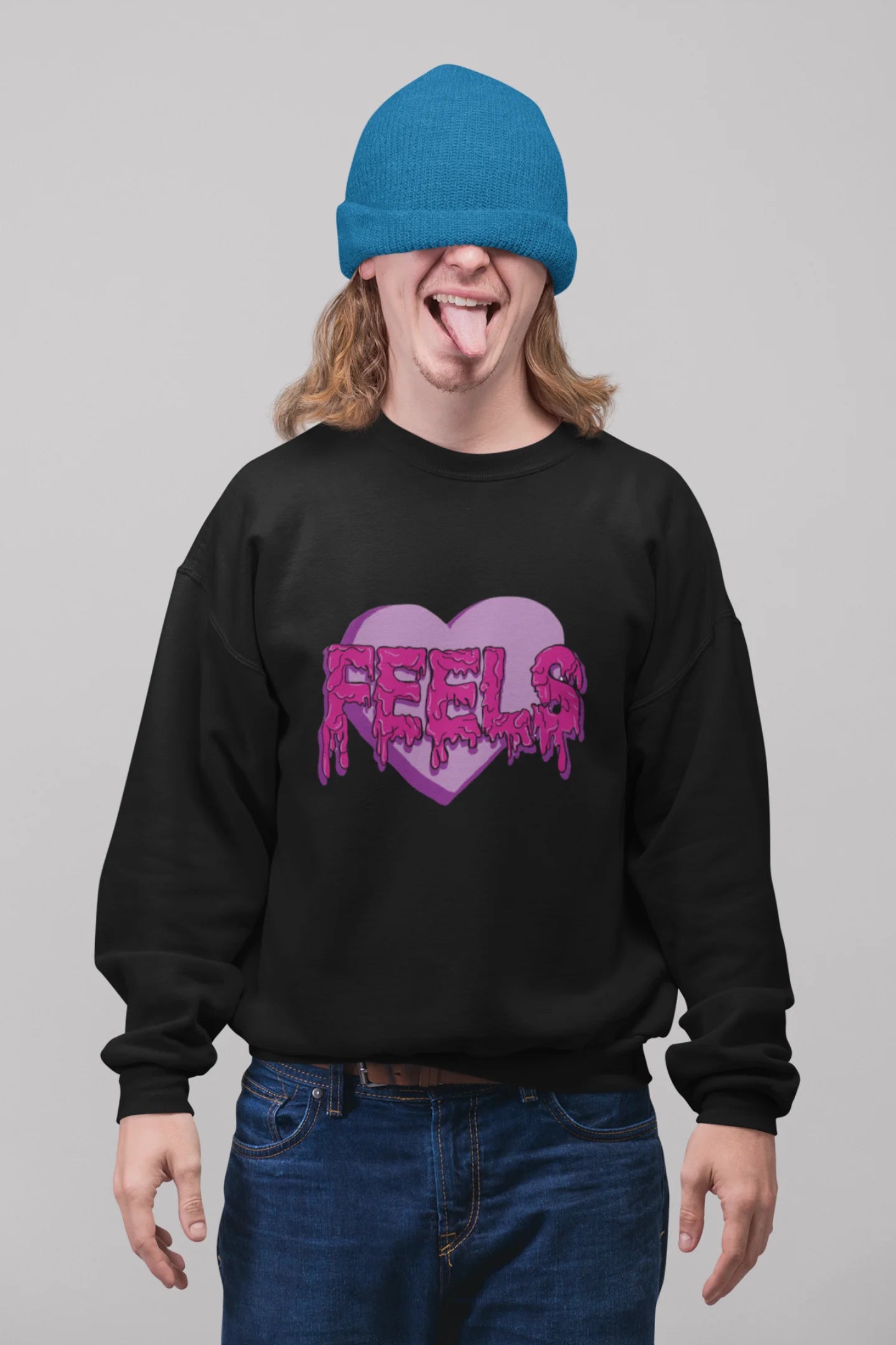2nd front view of a male model wearing a black sweatshirt featuring a heart with melting "Feels" text.