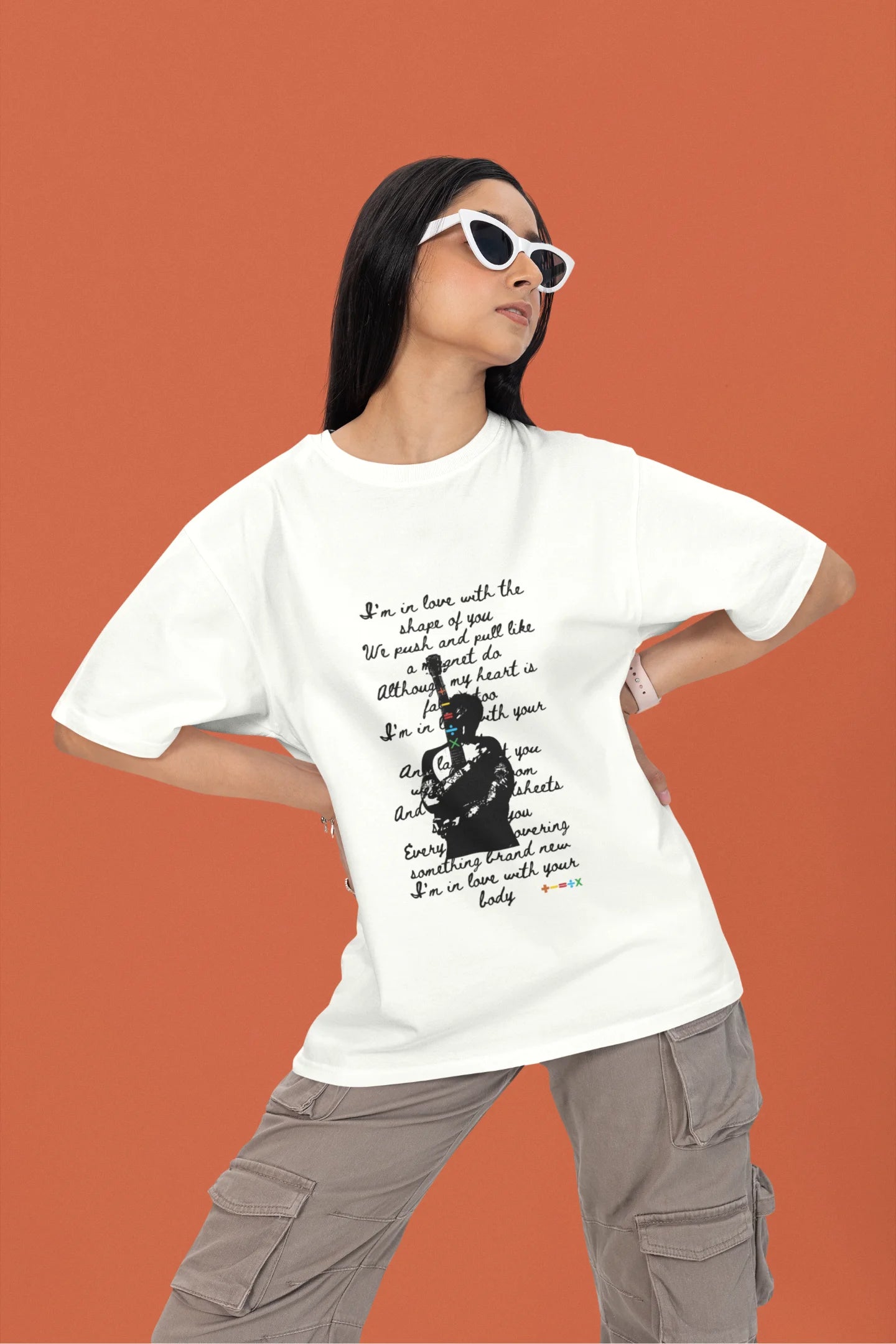 First front view of a female model wearing a off-white oversized t-shirt featuring a design inspired by Ed Sheeran's concerts, related to the song "Shape of You."