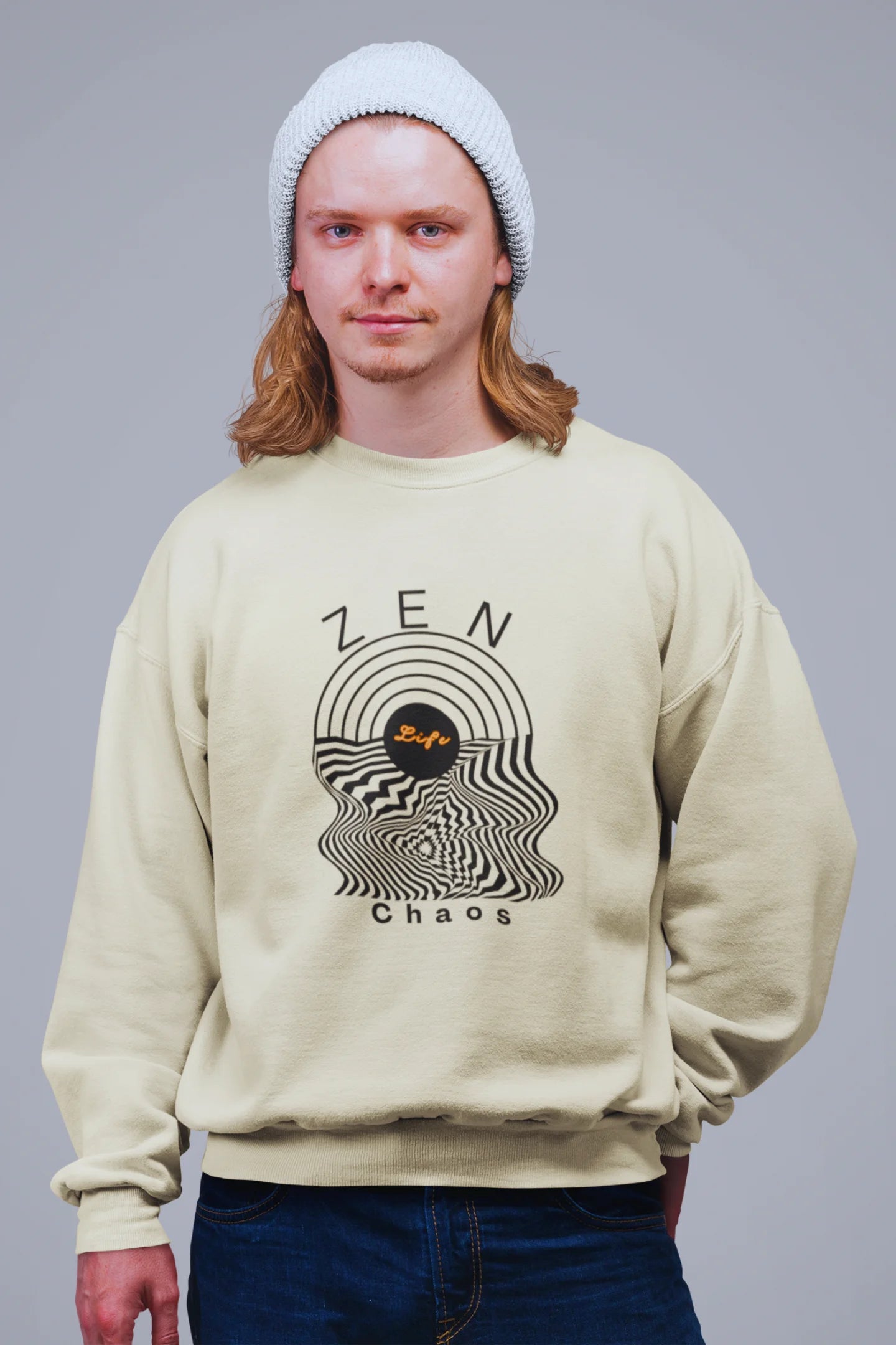 4th front view of a male model wearing an cream sweatshirt featuring an aesthetic design of a setting sun and crashing waves with the text "Zen & Chaos" above it. Ideal for those who love philosophical themes and visually striking clothing.