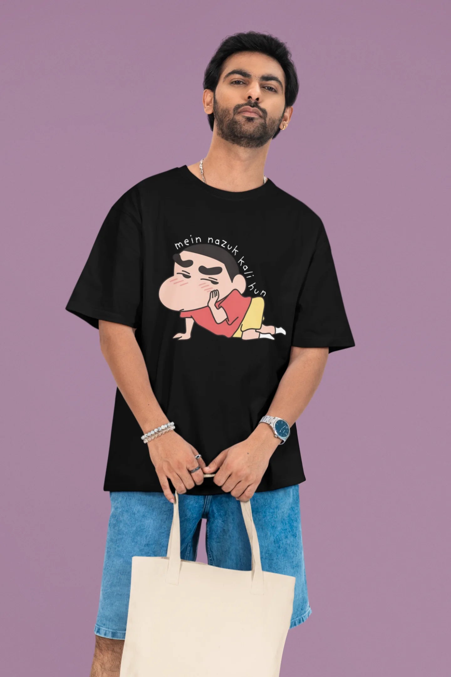 2nd front view of a male model wearing a black oversized t-shirt featuring Shinchan saying "Mein Nazuk Kali Hun."