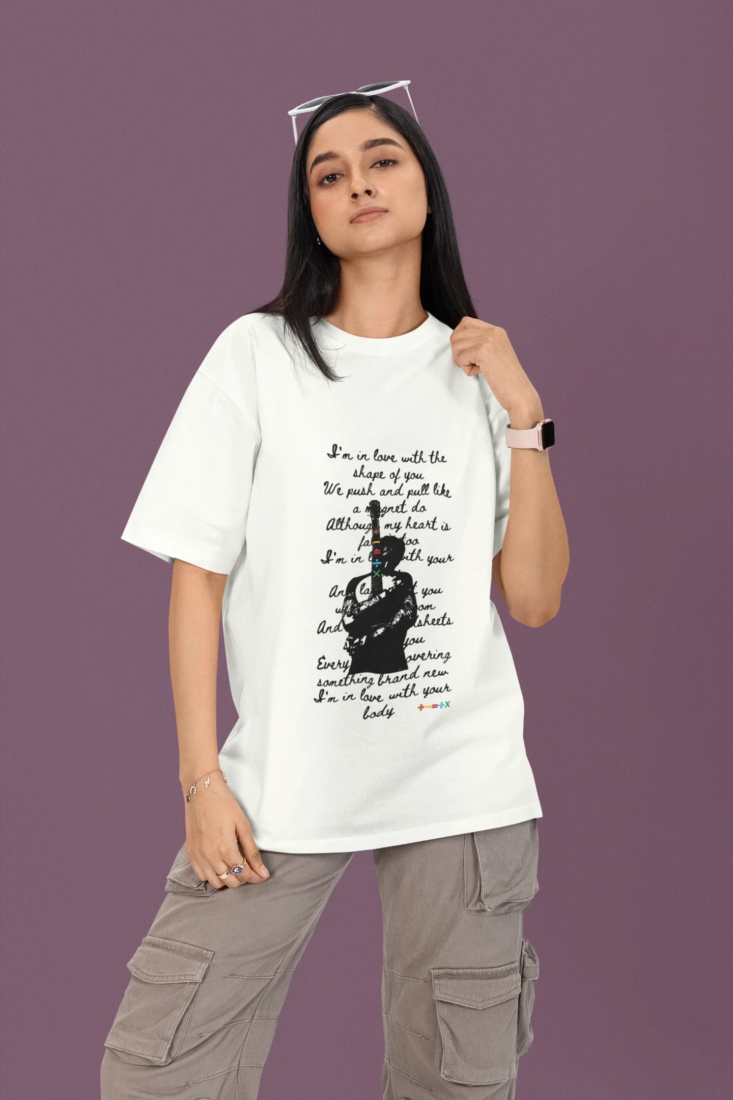 2nd front view of a female model wearing a off-white oversized t-shirt featuring a design inspired by Ed Sheeran's concerts, related to the song "Shape of You."