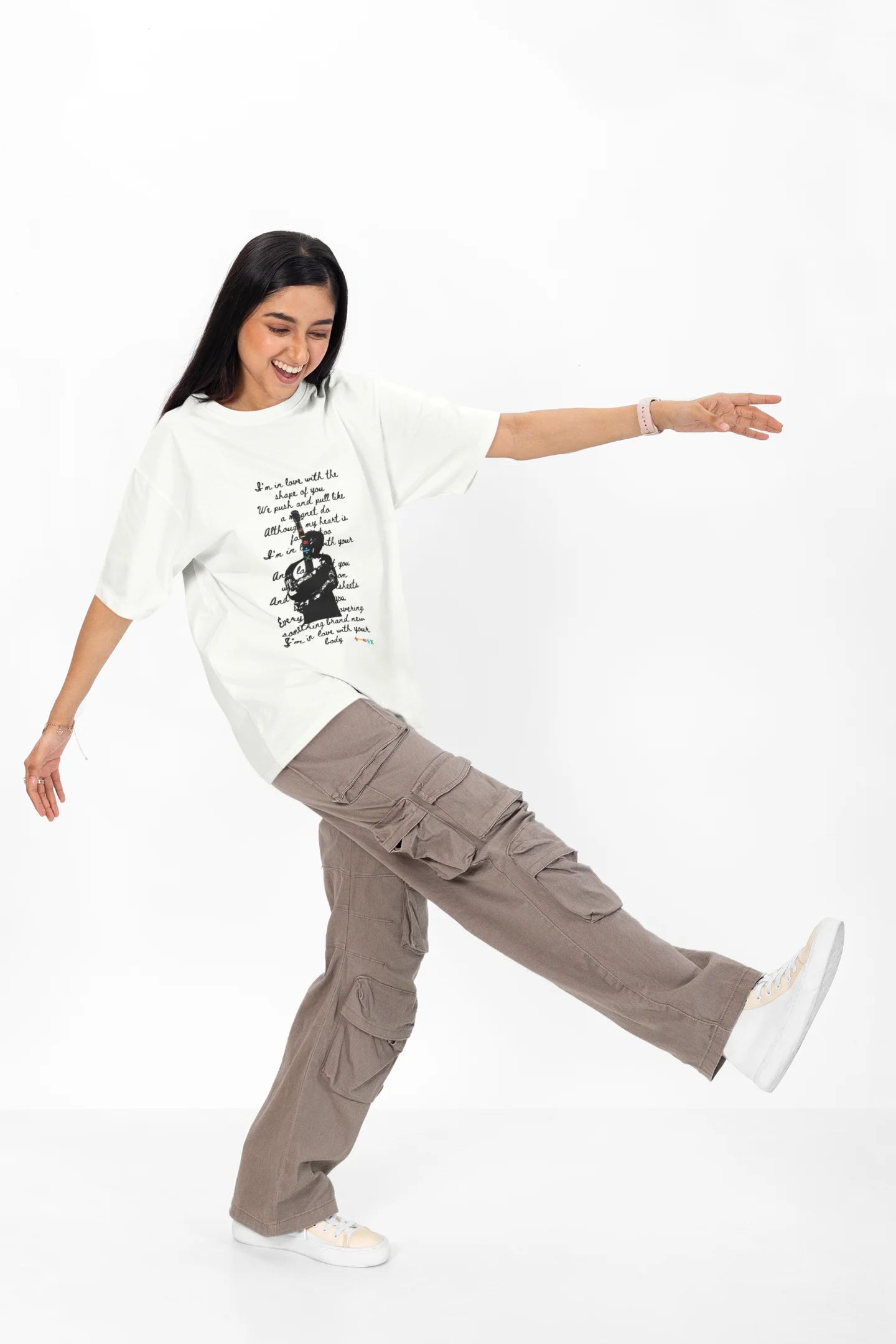 4th front view of a female model wearing a off-white oversized t-shirt featuring a design inspired by Ed Sheeran's concerts, related to the song "Shape of You."