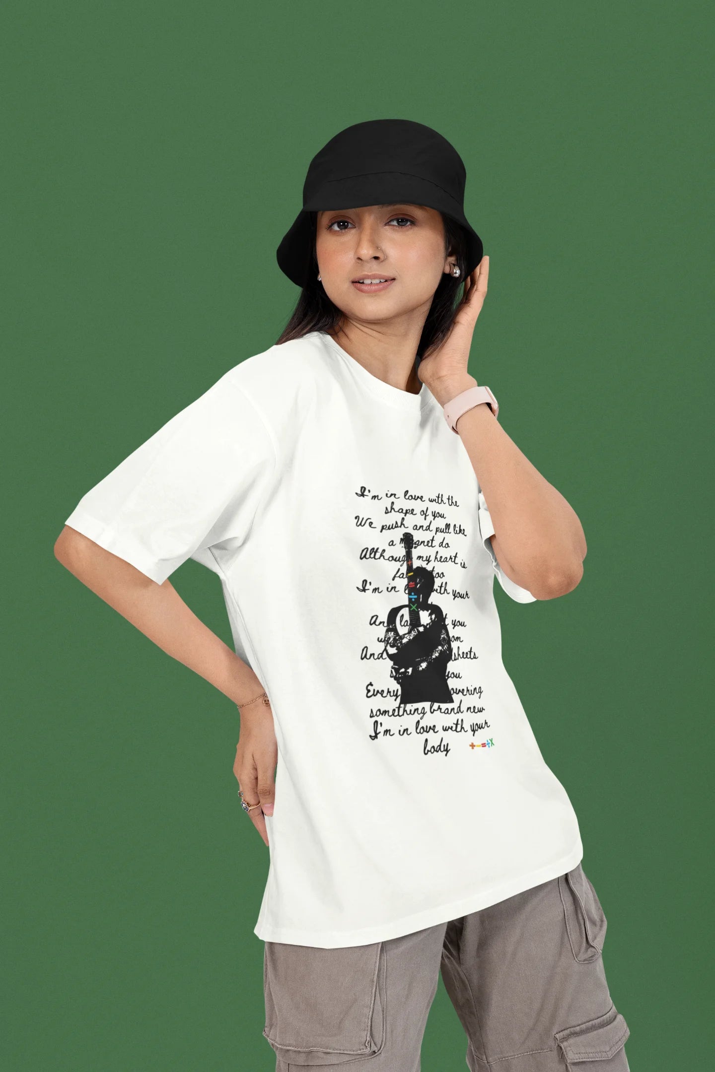 3rd front view of a female model wearing a off-white oversized t-shirt featuring a design inspired by Ed Sheeran's concerts, related to the song "Shape of You."