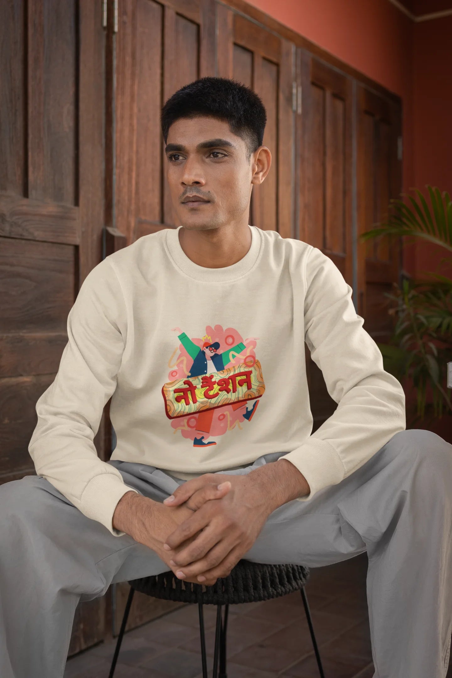First front view of a male model wearing a cream oversized t-shirt with the phrase "No Tension" in a relaxed, unique script.