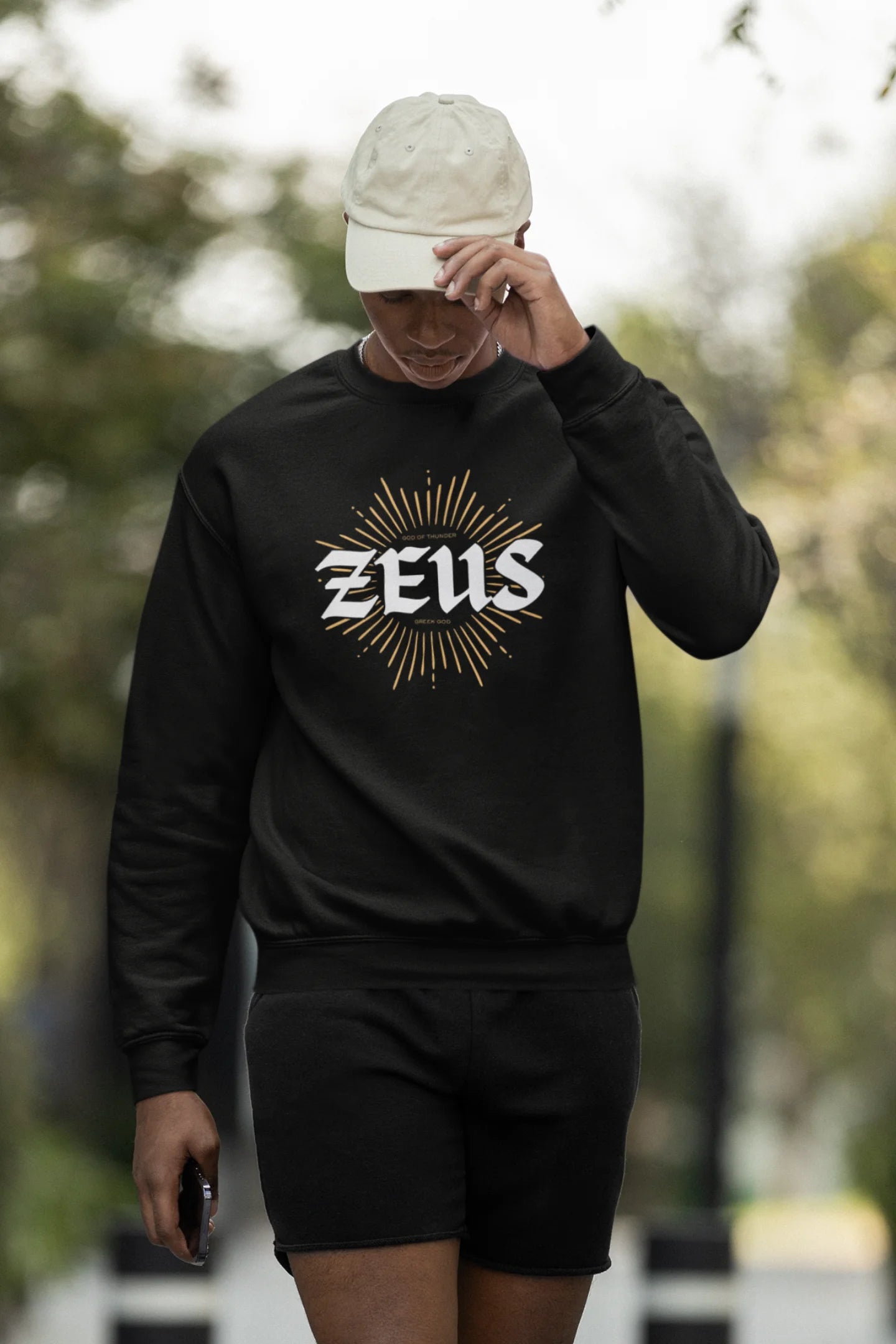 Third front view of a male model wearing a brutalist-inspired black sweatshirt with a stylized image of Zeus, king of the gods, in a concrete-like design.
