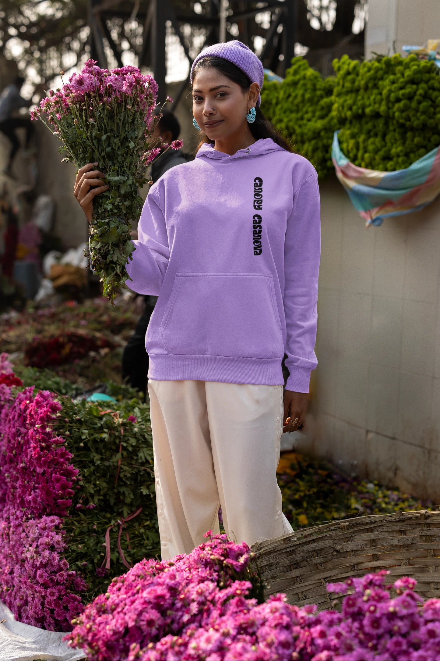 Second front view of a female model wearing a lavender hoodie with a toucan perched on a branch in a jungle setting.
