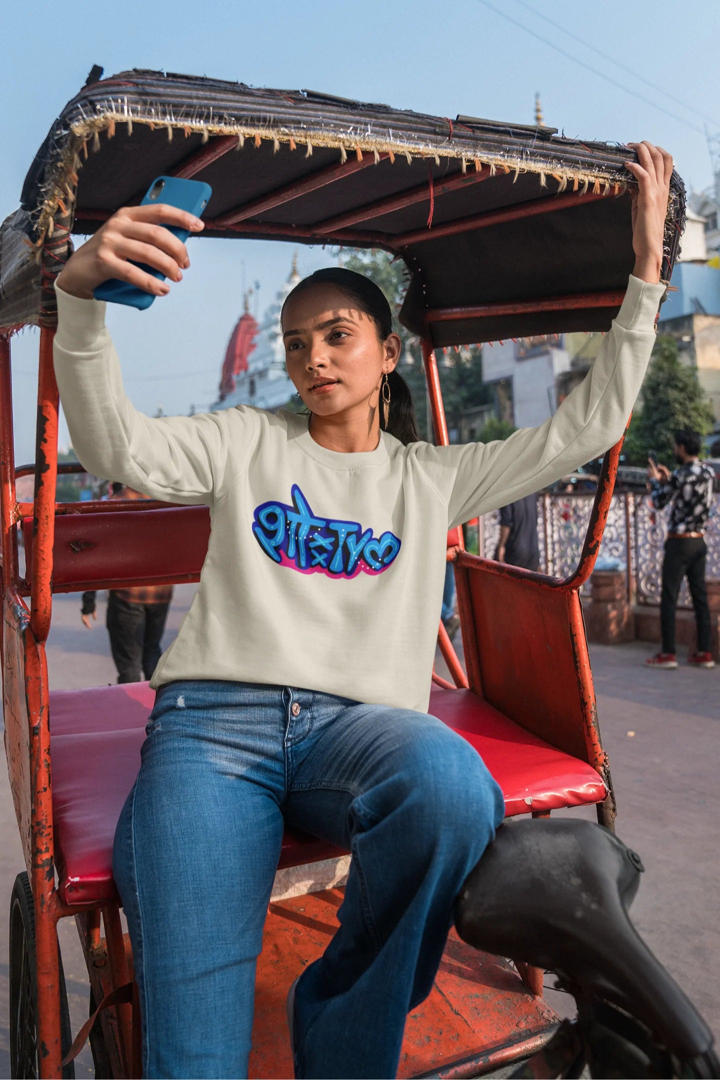 2nd front view of a female model wearing a cream oversized t-shirt featuring "Showtime" in Hindi.