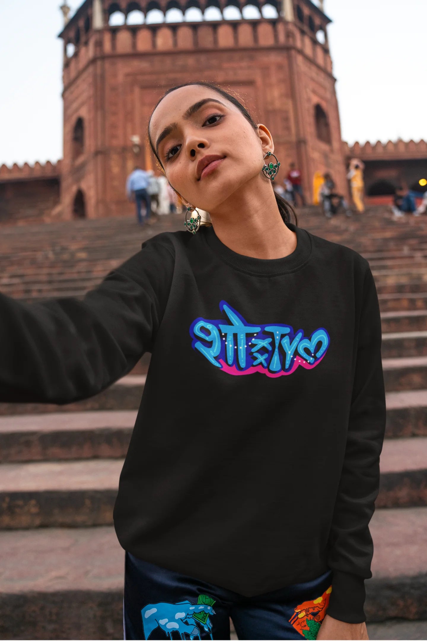 First front view of a female model wearing a black oversized t-shirt featuring "Showtime" in Hindi.