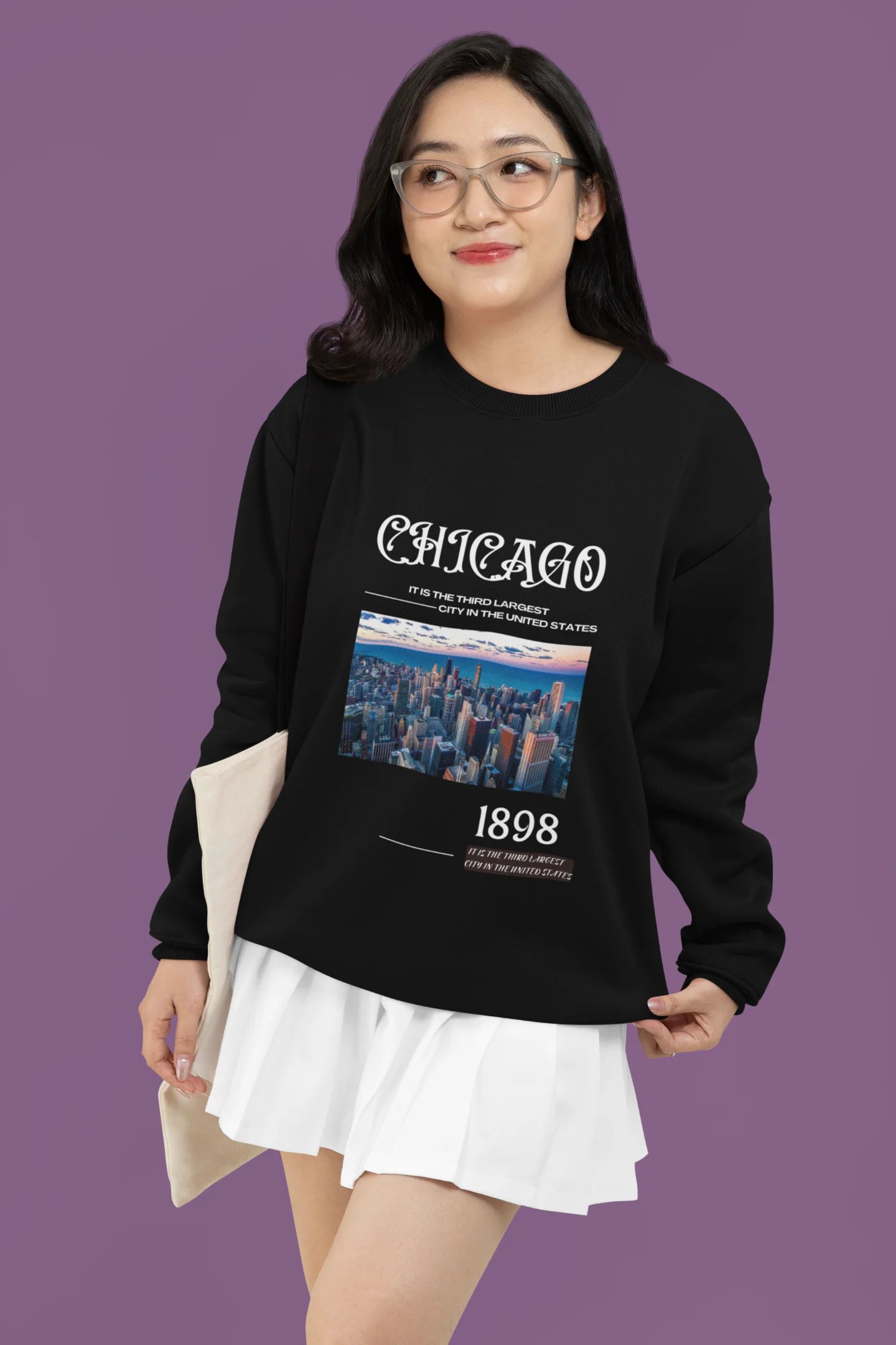 First front view of female model wearing a black sweatshirt with a Chicago skyline design, offering a relaxed urban aesthetic.